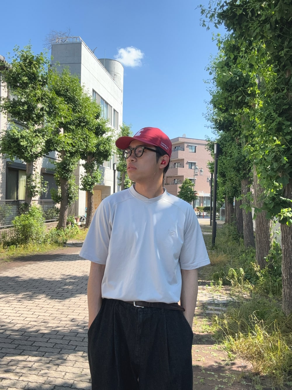 グレー系のTシャツ/カットソー、ブラック系のデニムパンツ、ブラック系のスニーカーを着用したメンズの夏コーディネートの2枚目の写真