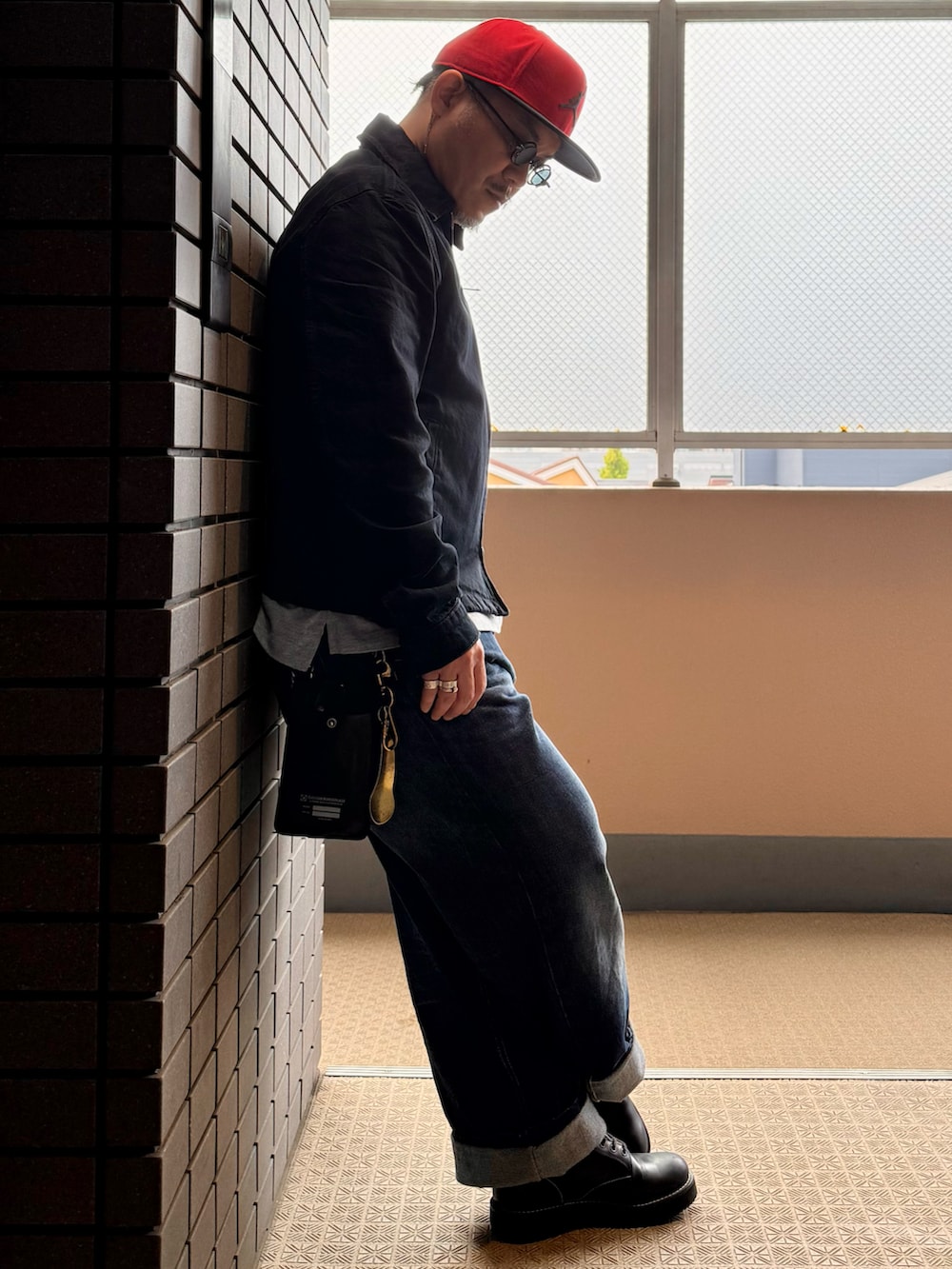 ブルー系のデニムパンツ、ブラック系のブーツ、ブルー系のデニムジャケットを着用したメンズの春コーディネートの2枚目の写真