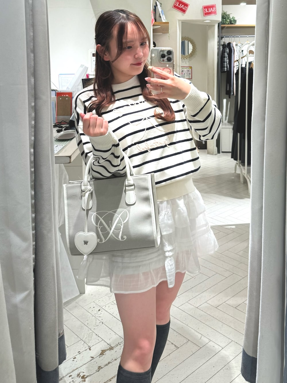 ブラック系のスニーカー、その他のニット/セーター、ベージュ系のトートバッグを着用したレディースの冬コーディネートの3枚目の写真