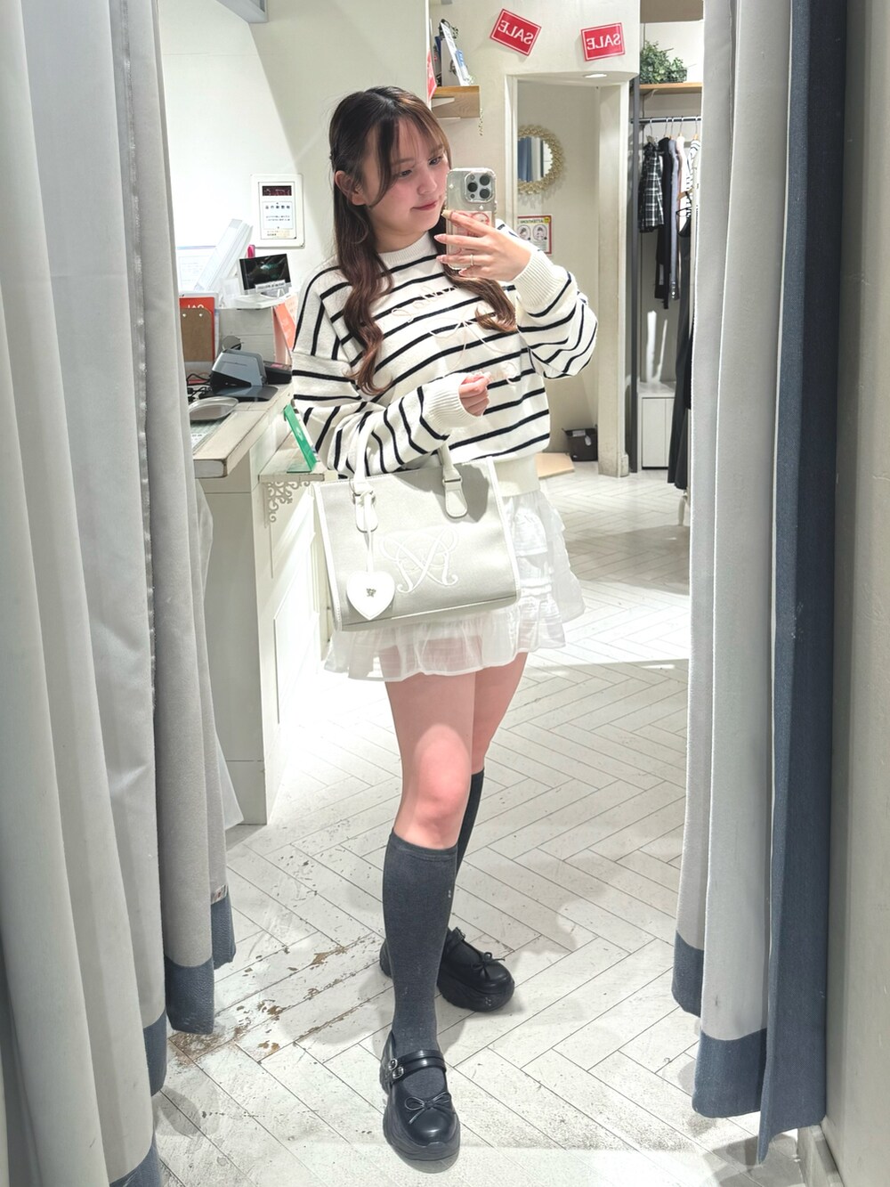 ブラック系のスニーカー、その他のニット/セーター、ベージュ系のトートバッグを着用したレディースの冬コーディネートの4枚目の写真