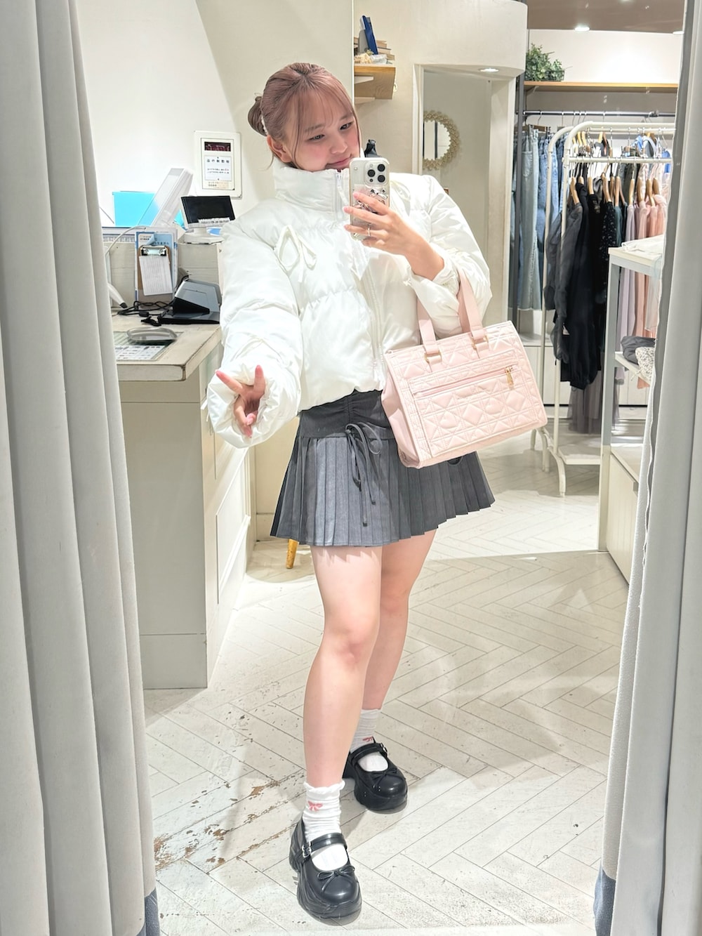 ホワイト系のダウンジャケット/コート、グレー系のスカート、ホワイト系のショルダーバッグを着用したレディースの秋コーディネートの3枚目の写真