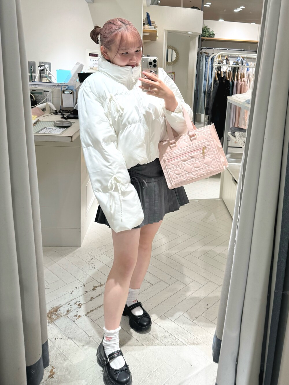 ホワイト系のダウンジャケット/コート、グレー系のスカート、ホワイト系のショルダーバッグを着用したレディースの秋コーディネートの2枚目の写真