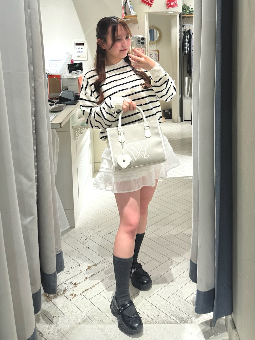 ブラック系のスニーカー、その他のニット/セーター、ベージュ系のトートバッグを着用したレディースの冬コーディネートの6枚目の写真