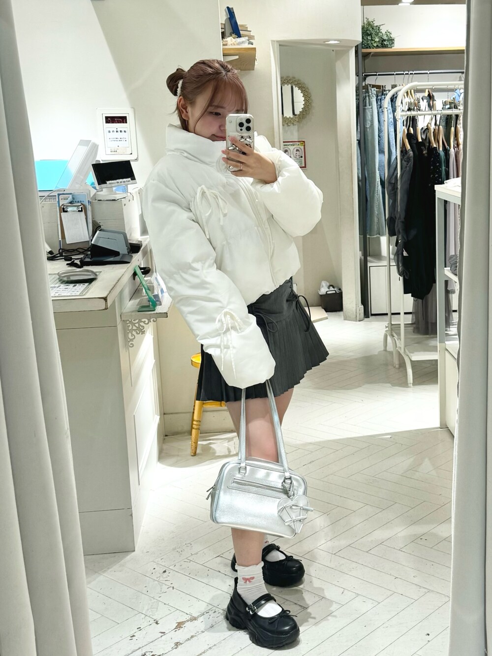 ホワイト系のダウンジャケット/コート、グレー系のスカート、ホワイト系のショルダーバッグを着用したレディースの秋コーディネートの6枚目の写真