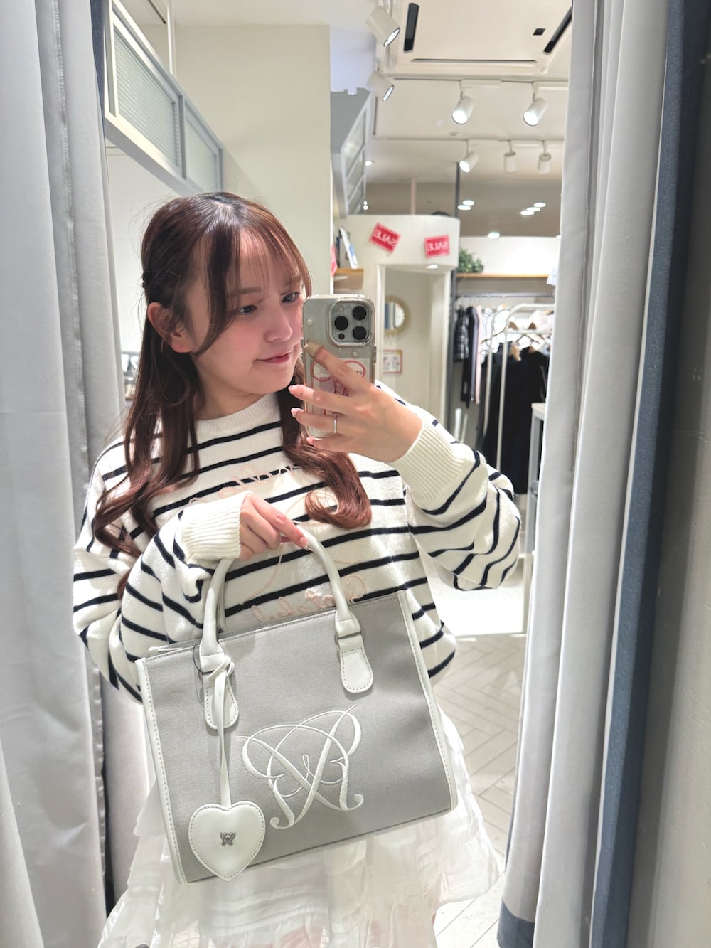 ブラック系のスニーカー、その他のニット/セーター、ベージュ系のトートバッグを着用したレディースの冬コーディネートの2枚目の写真