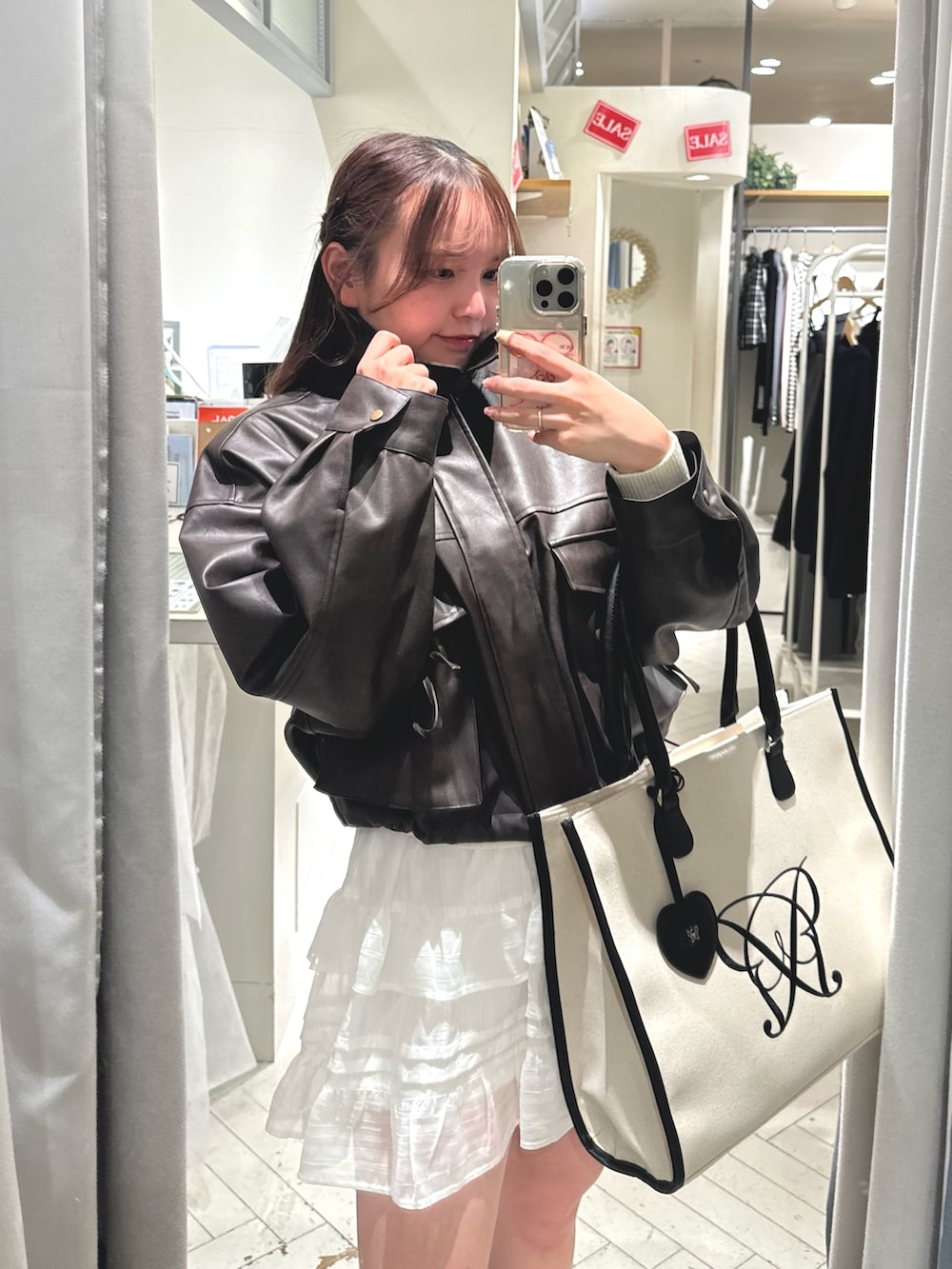 ホワイト系のスカート、ブラウン系のブルゾン、ホワイト系のトートバッグを着用したレディースの冬コーディネートの5枚目の写真