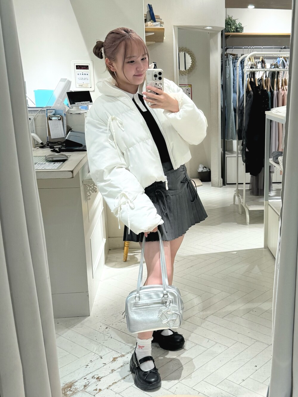 ホワイト系のダウンジャケット/コート、グレー系のスカート、ホワイト系のショルダーバッグを着用したレディースの秋コーディネートの7枚目の写真