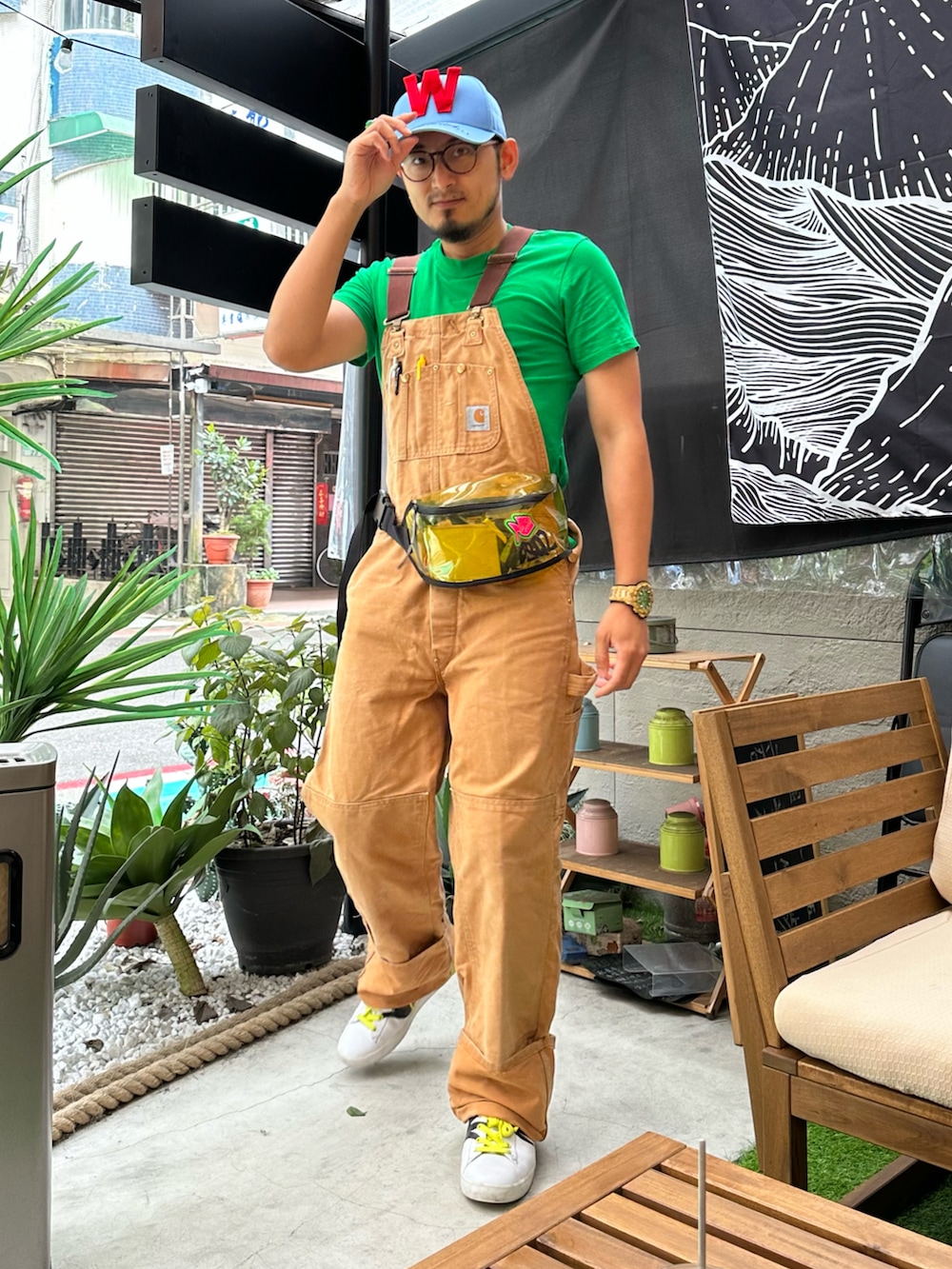 ブラウン系のサロペット/オーバーオール、イエロー系のスニーカー、イエロー系のボディバッグ/ウエストポーチを着用したメンズの春コーディネートの2枚目の写真