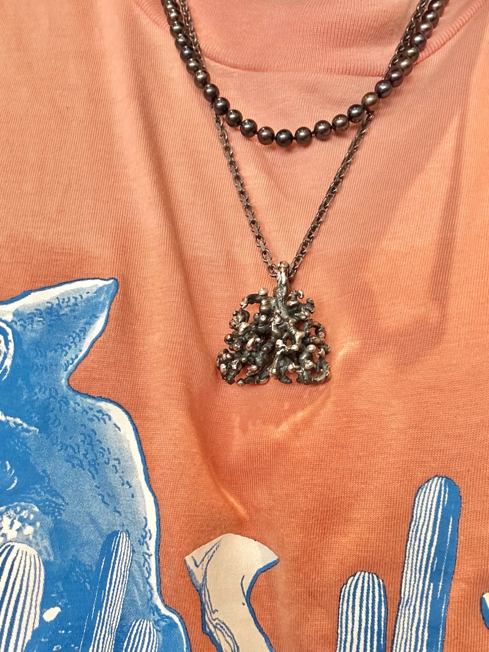 ピンク系のTシャツ/カットソー、ブラック系のカーゴパンツ、その他のスニーカーを着用したメンズの夏コーディネートの2枚目の写真