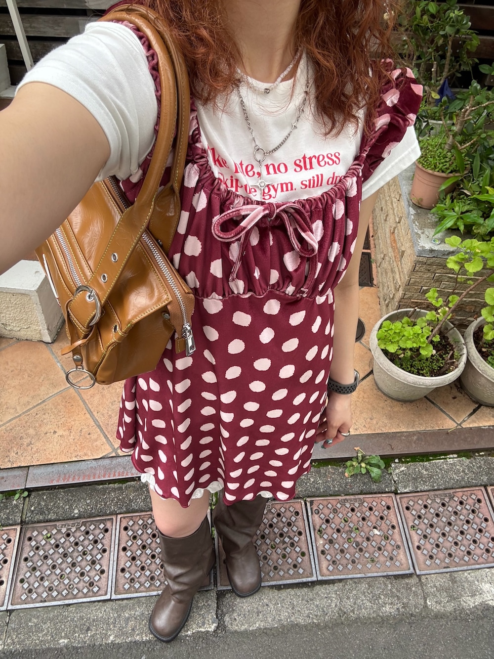 ホワイト系のTシャツ/カットソー、レッド系のチュニック、ブラウン系のブーツを着用したレディースの夏コーディネートの2枚目の写真