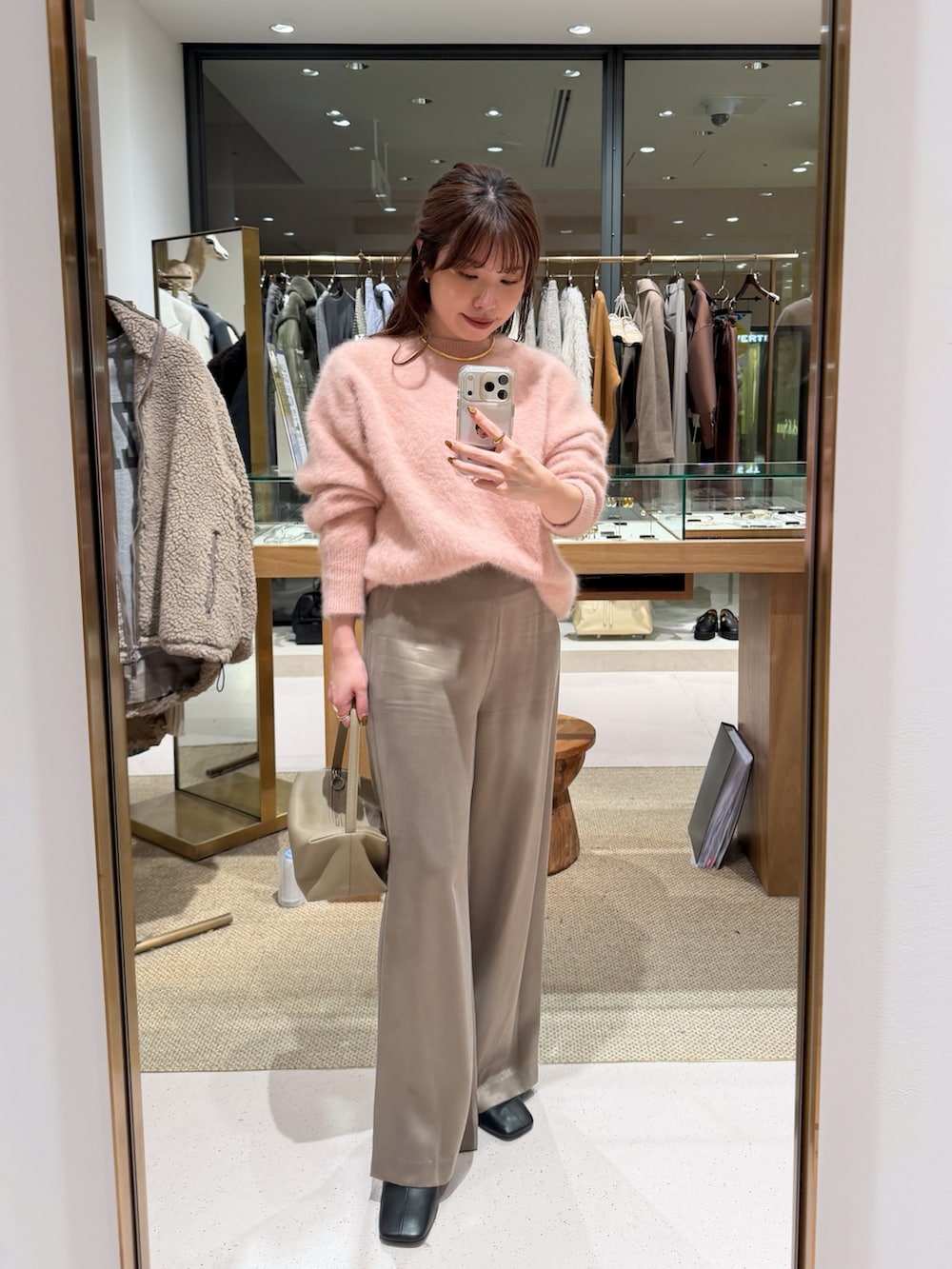 ピンク系のニット/セーター、ベージュ系のハンドバッグ、ベージュ系のその他パンツを着用したレディースの秋コーディネートの2枚目の写真