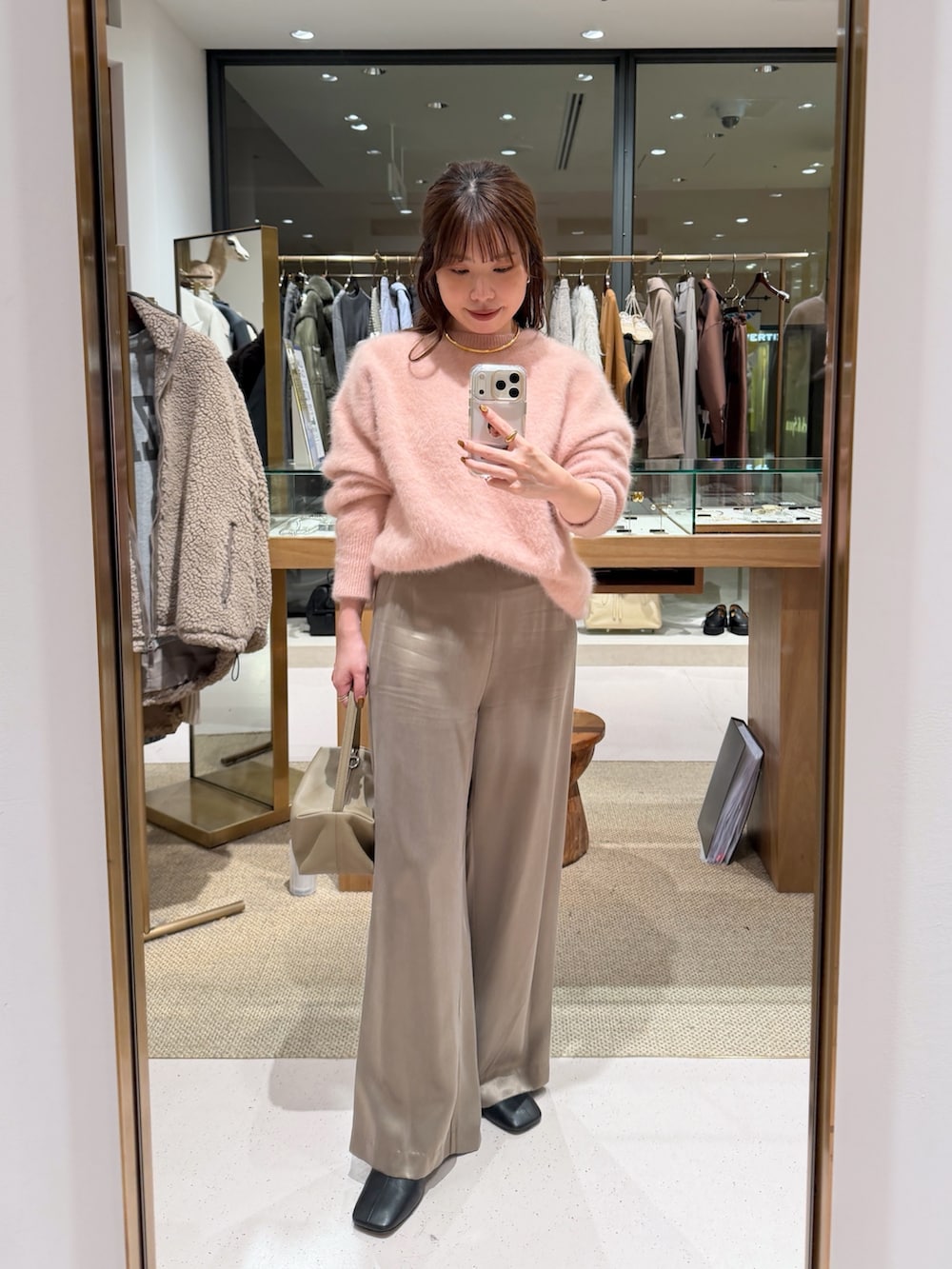 ピンク系のニット/セーター、ベージュ系のハンドバッグ、ベージュ系のその他パンツを着用したレディースの秋コーディネートの6枚目の写真