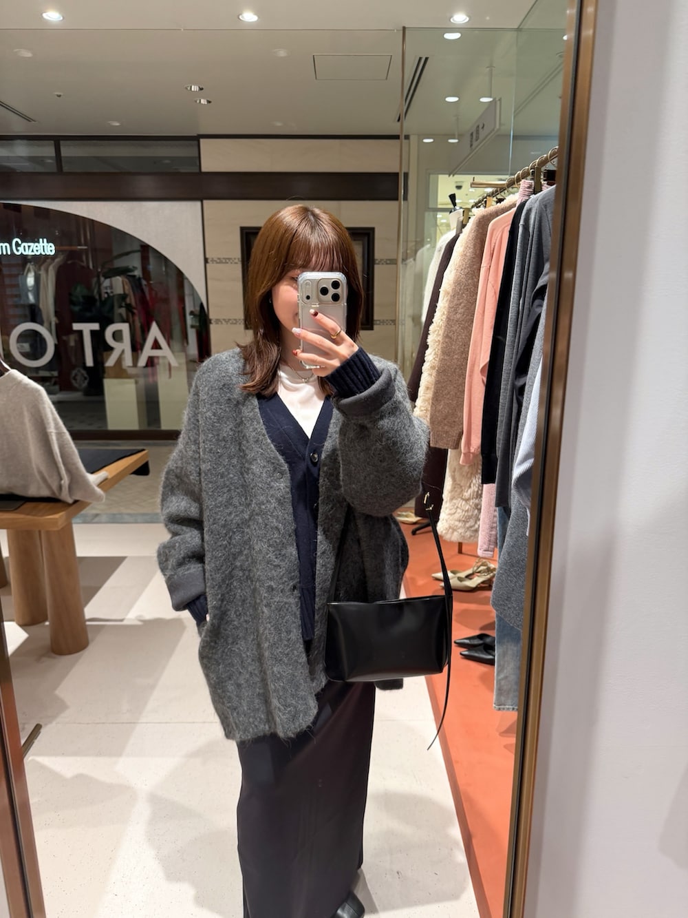 ホワイト系のTシャツ/カットソー、ブラック系のスカート、ブラック系のブーツを着用したレディースの秋コーディネートの3枚目の写真