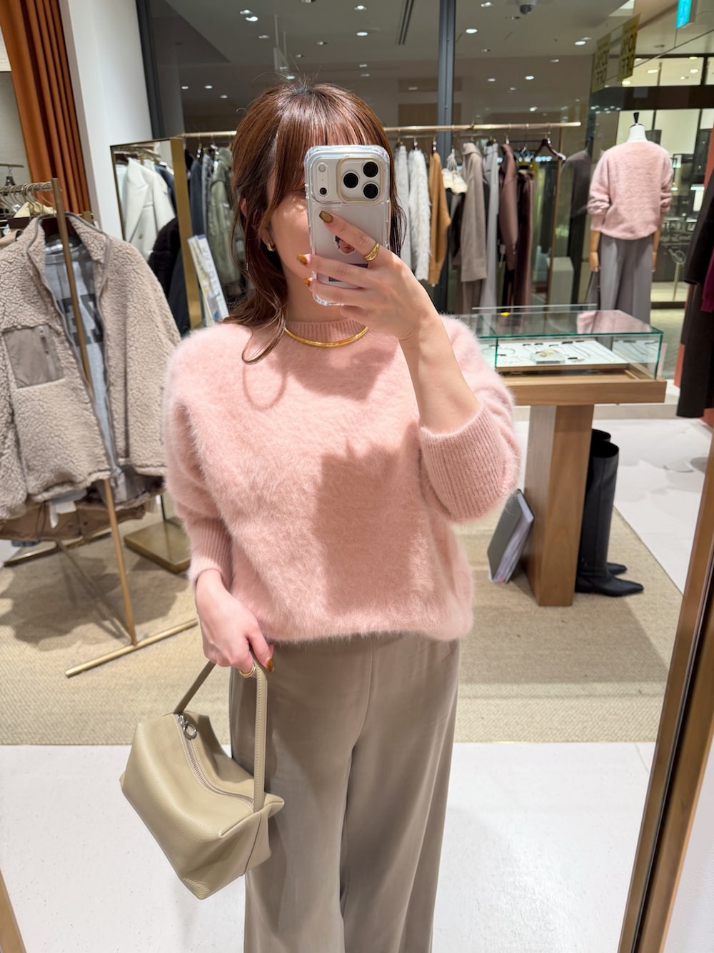 ピンク系のニット/セーター、ベージュ系のハンドバッグ、ベージュ系のその他パンツを着用したレディースの秋コーディネートの4枚目の写真