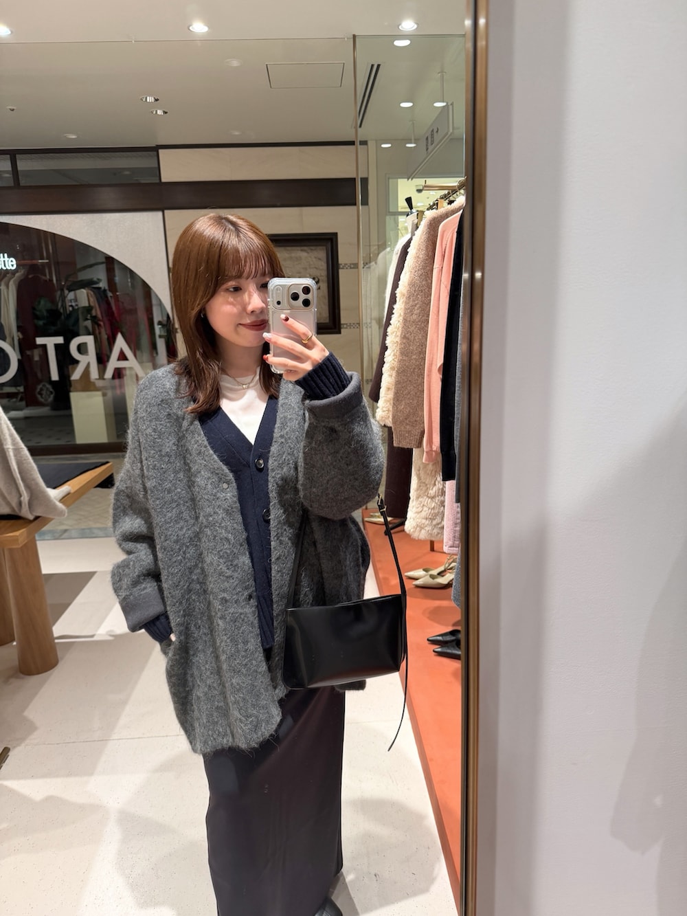 ホワイト系のTシャツ/カットソー、ブラック系のスカート、ブラック系のブーツを着用したレディースの秋コーディネートの2枚目の写真