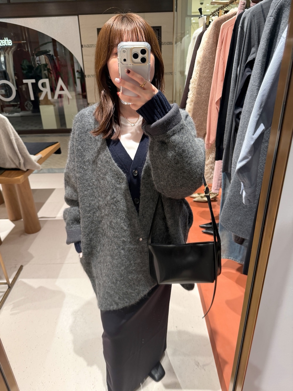 ホワイト系のTシャツ/カットソー、ブラック系のスカート、ブラック系のブーツを着用したレディースの秋コーディネートの5枚目の写真