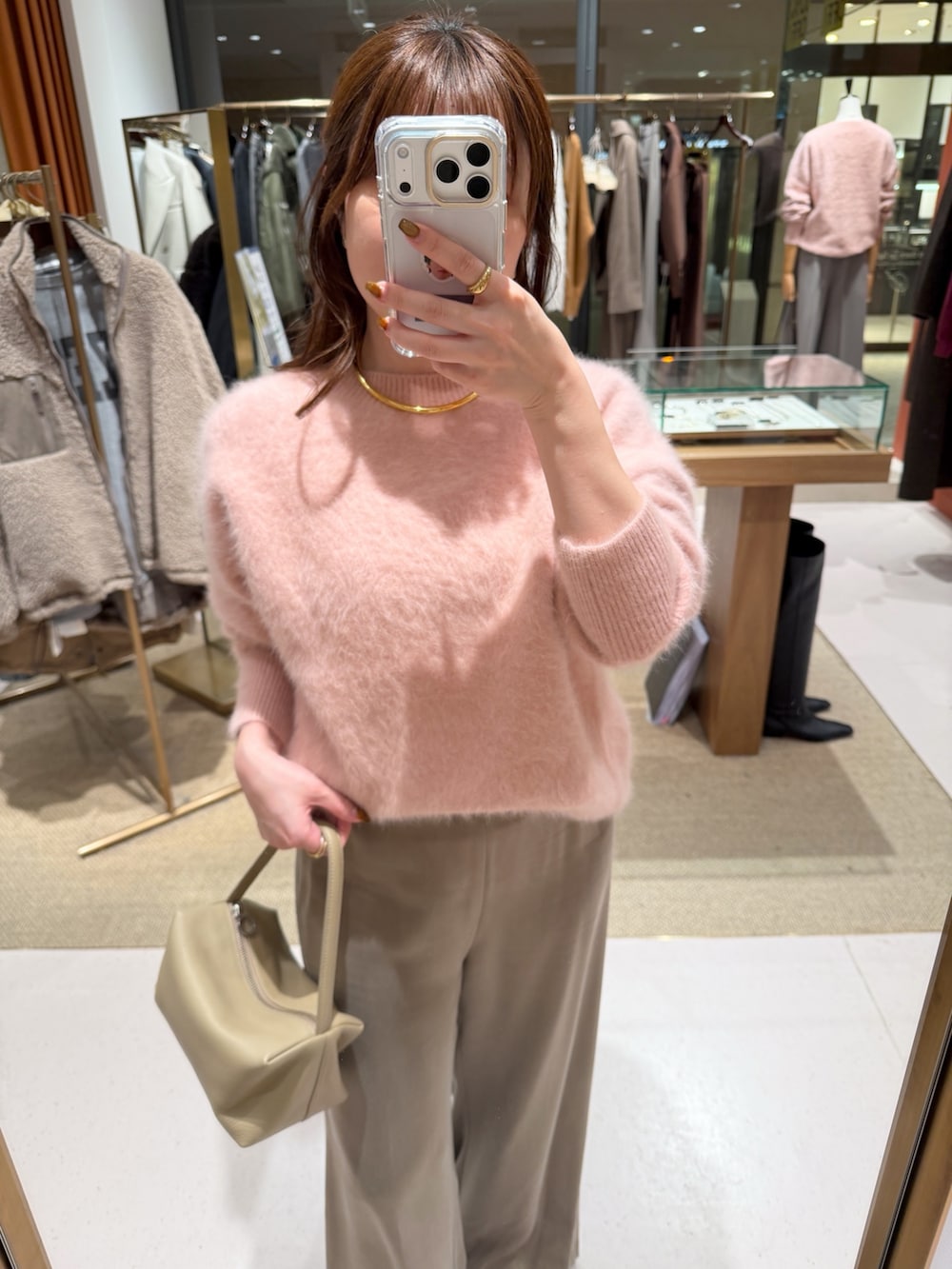 ピンク系のニット/セーター、ベージュ系のハンドバッグ、ベージュ系のその他パンツを着用したレディースの秋コーディネートの5枚目の写真