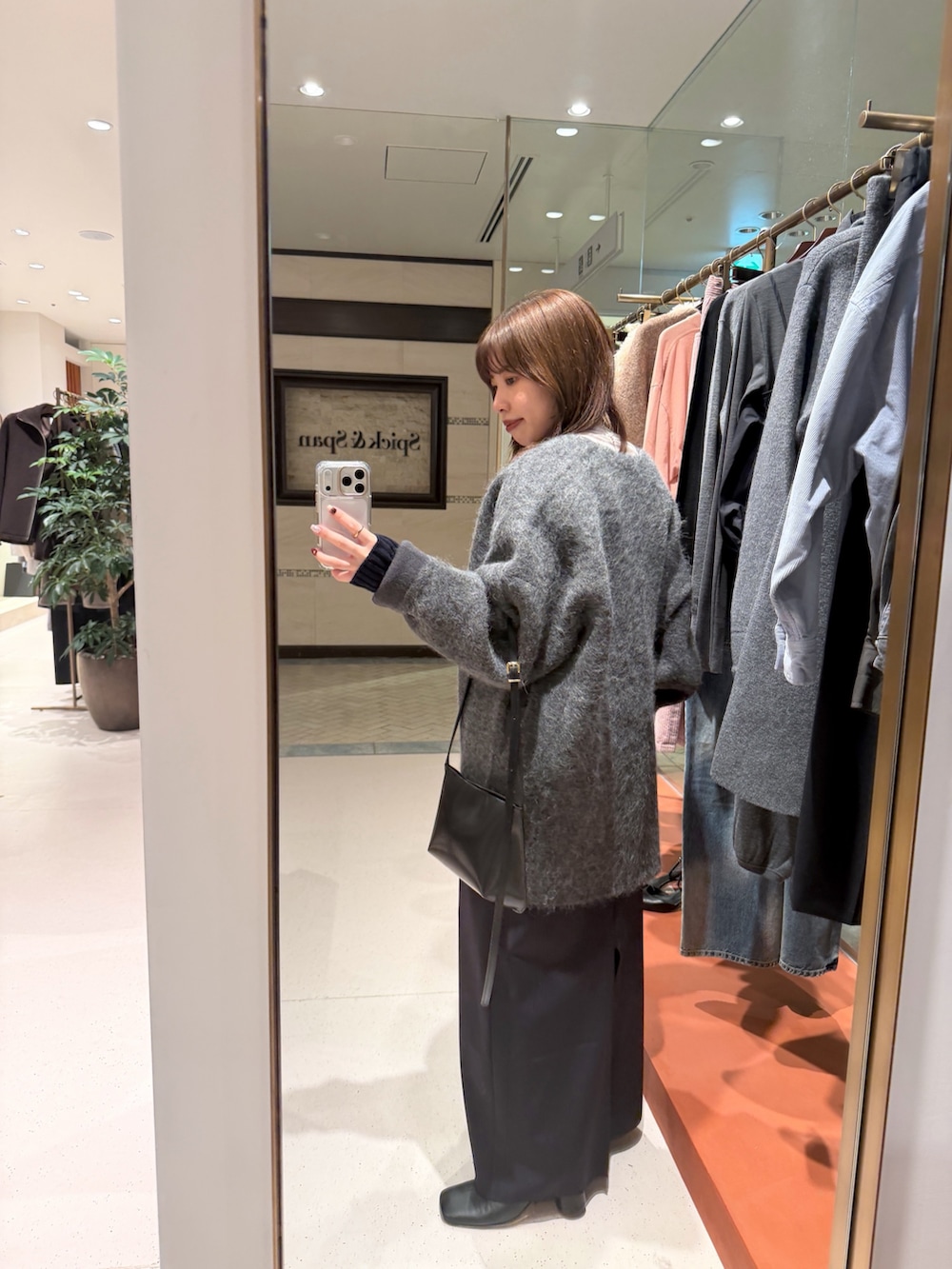 ホワイト系のTシャツ/カットソー、ブラック系のスカート、ブラック系のブーツを着用したレディースの秋コーディネートの4枚目の写真