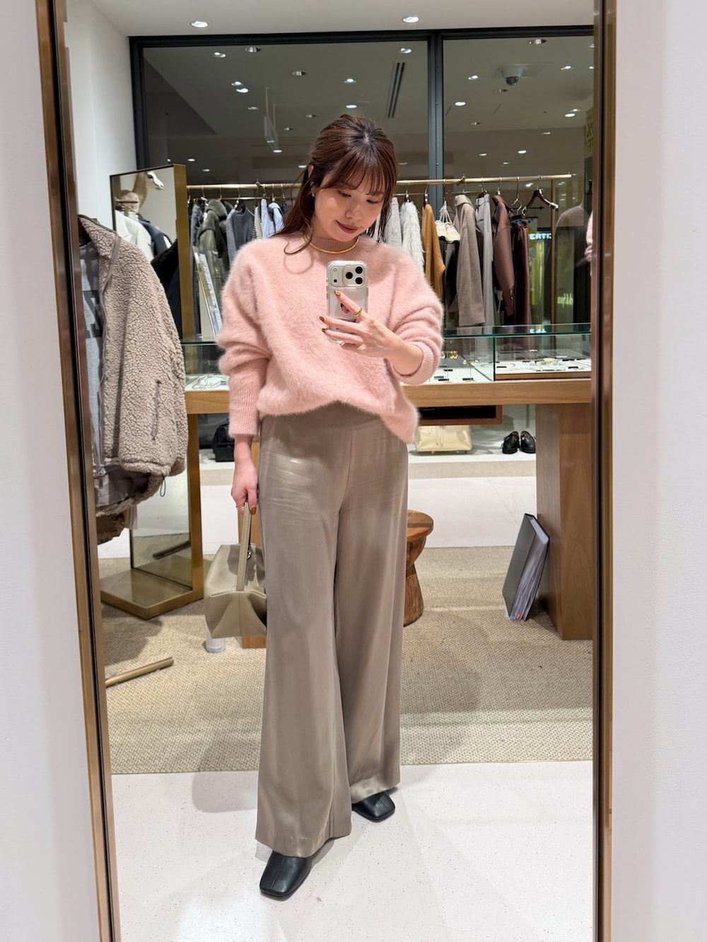 ピンク系のニット/セーター、ベージュ系のハンドバッグ、ベージュ系のその他パンツを着用したレディースの秋コーディネートの8枚目の写真