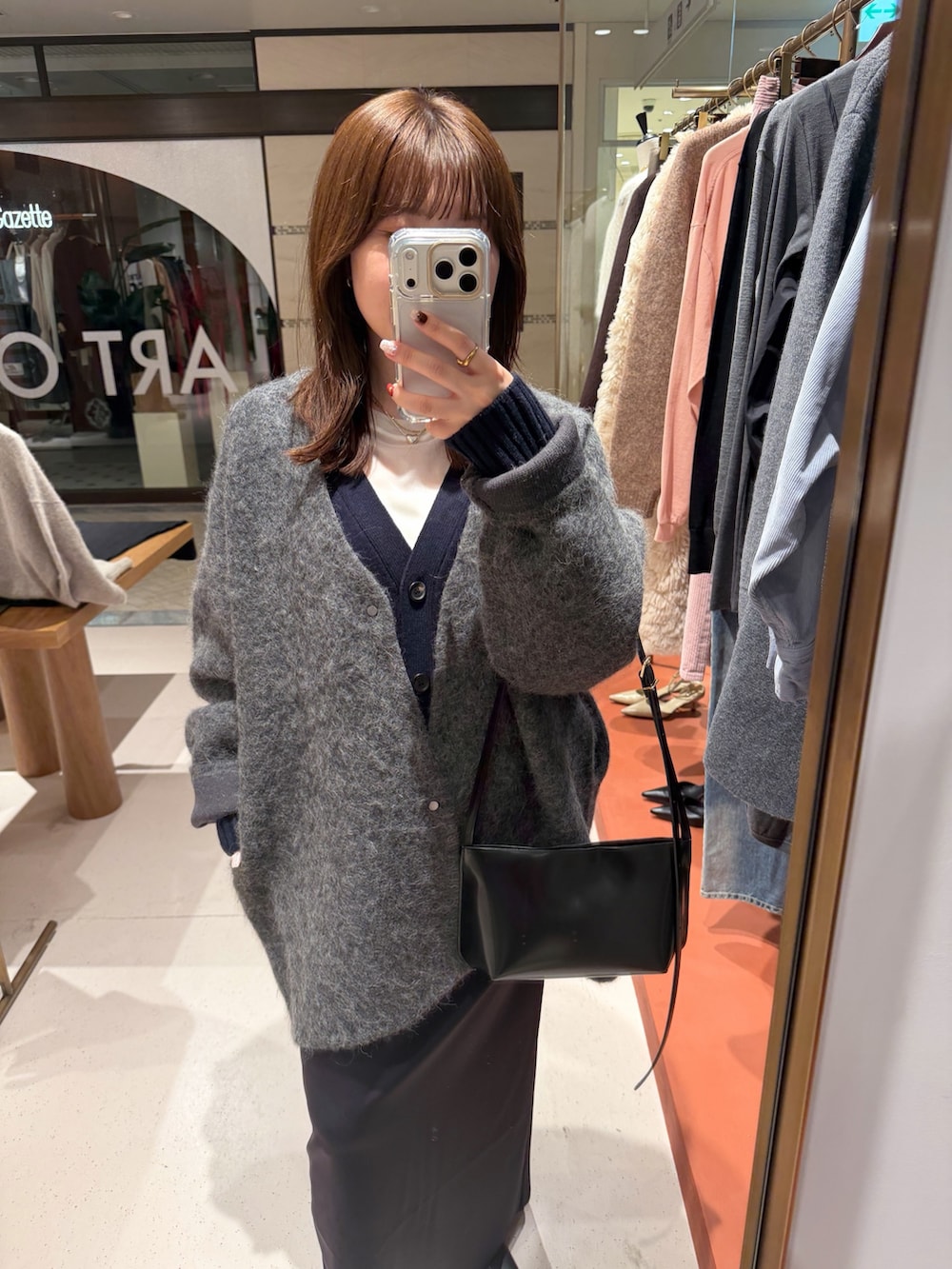 ホワイト系のTシャツ/カットソー、ブラック系のスカート、ブラック系のブーツを着用したレディースの秋コーディネートの6枚目の写真