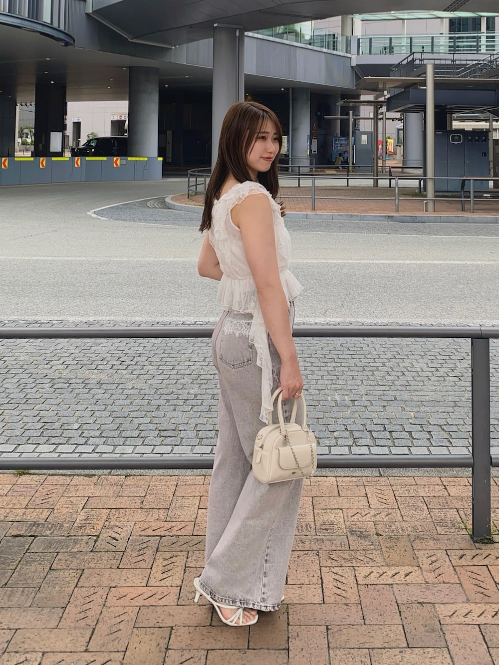 ピンク系のデニムパンツ、ホワイト系のサンダル、ホワイト系のボストンバッグを着用したレディースの夏コーディネートの3枚目の写真