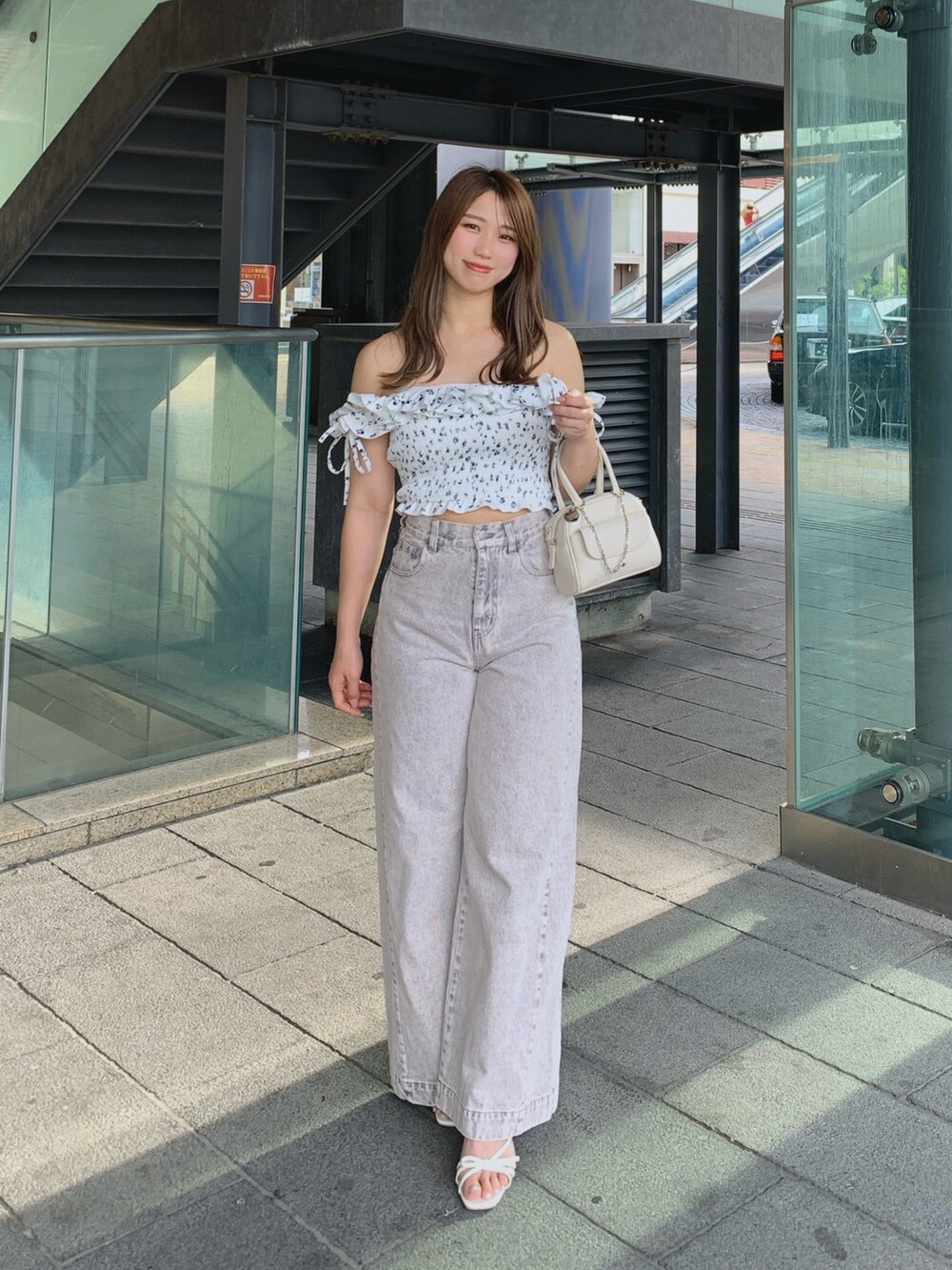 ホワイト系のボストンバッグ、ピンク系のデニムパンツ、ホワイト系のサンダルを着用したレディースの夏コーディネートの4枚目の写真