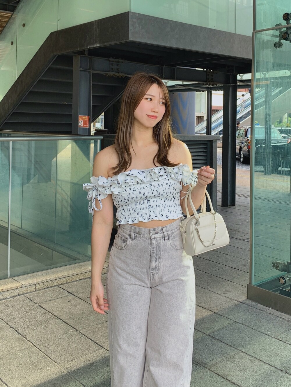 ホワイト系のボストンバッグ、ピンク系のデニムパンツ、ホワイト系のサンダルを着用したレディースの夏コーディネートの2枚目の写真