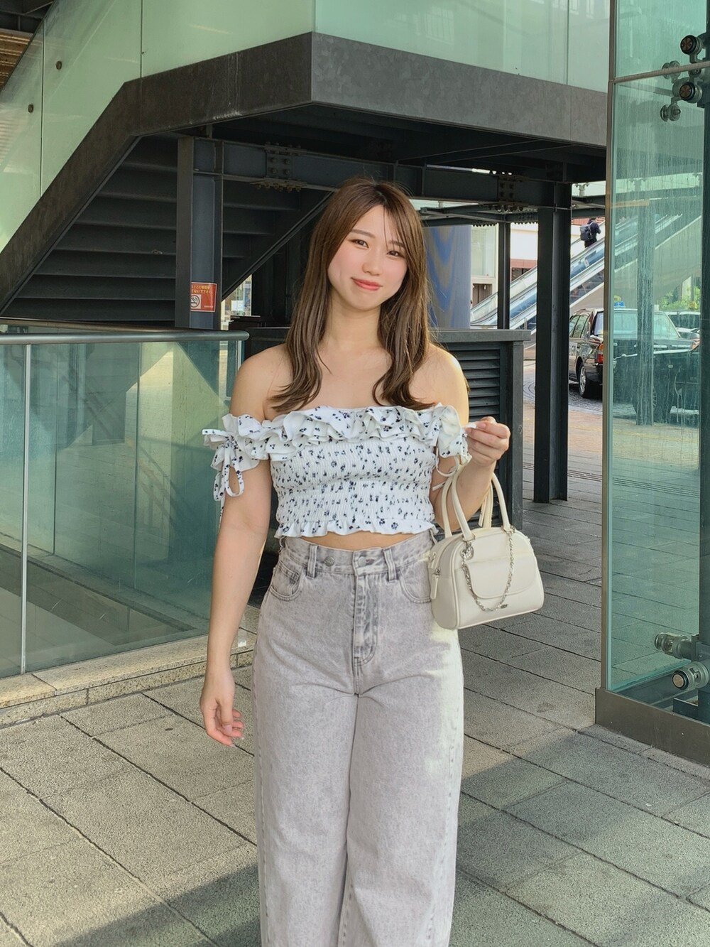 ホワイト系のボストンバッグ、ピンク系のデニムパンツ、ホワイト系のサンダルを着用したレディースの夏コーディネートの3枚目の写真