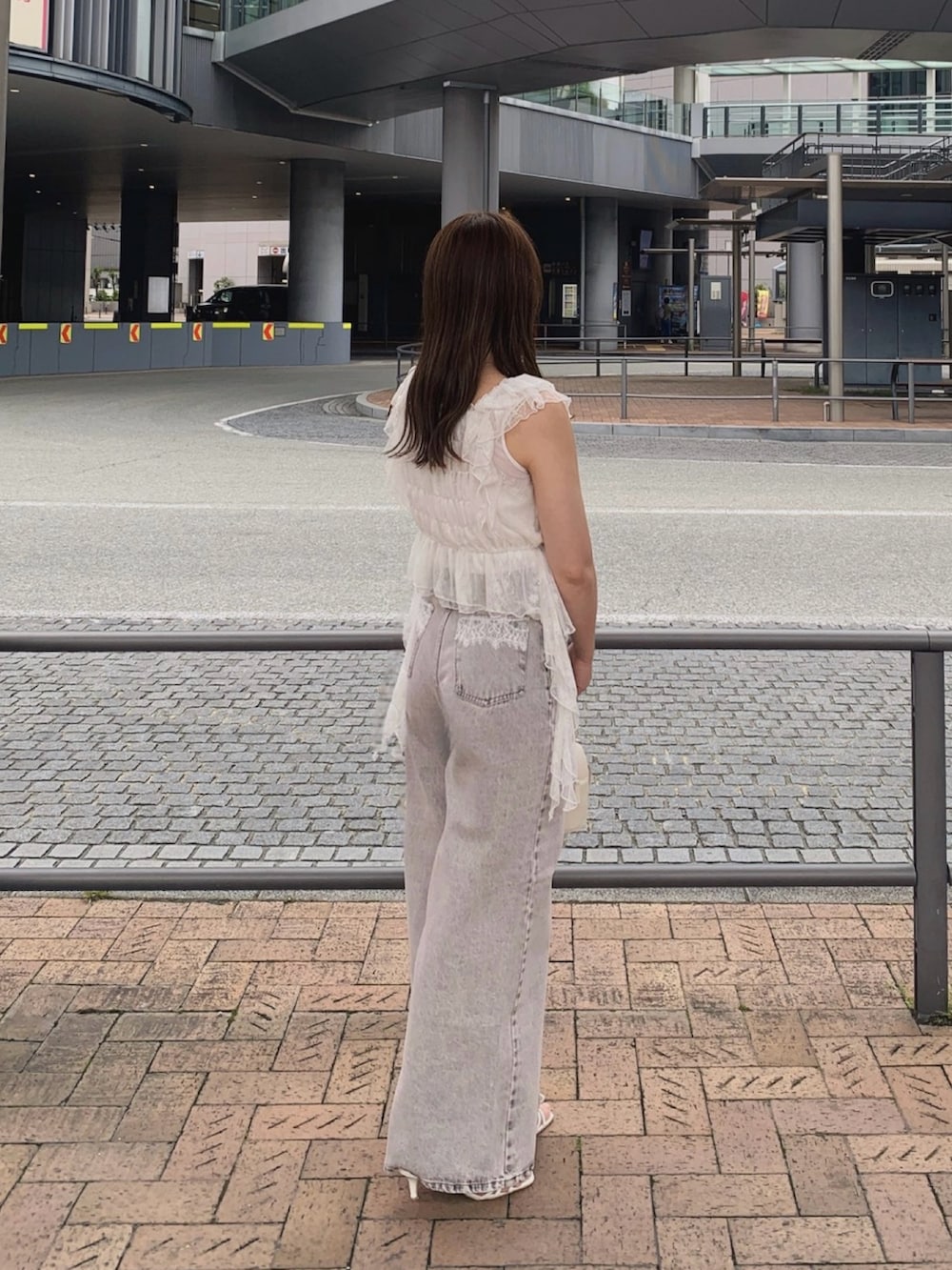 ピンク系のデニムパンツ、ホワイト系のサンダル、ホワイト系のボストンバッグを着用したレディースの夏コーディネートの5枚目の写真