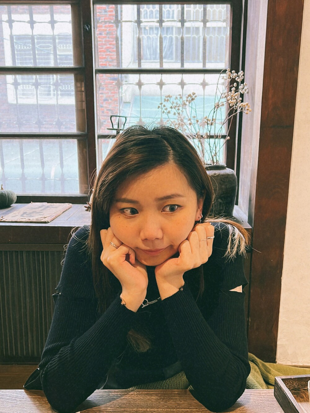 グリーン系のカーディガン/ボレロ、ブラック系のニット/セーターを着用したレディースの秋コーディネートの2枚目の写真