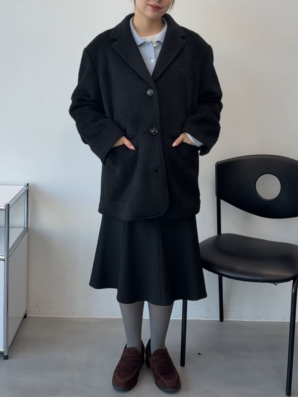 ブルー系のカーディガン/ボレロ、ブラック系のテーラードジャケット、ブラック系のスカートを着用したレディースの冬コーディネートの2枚目の写真