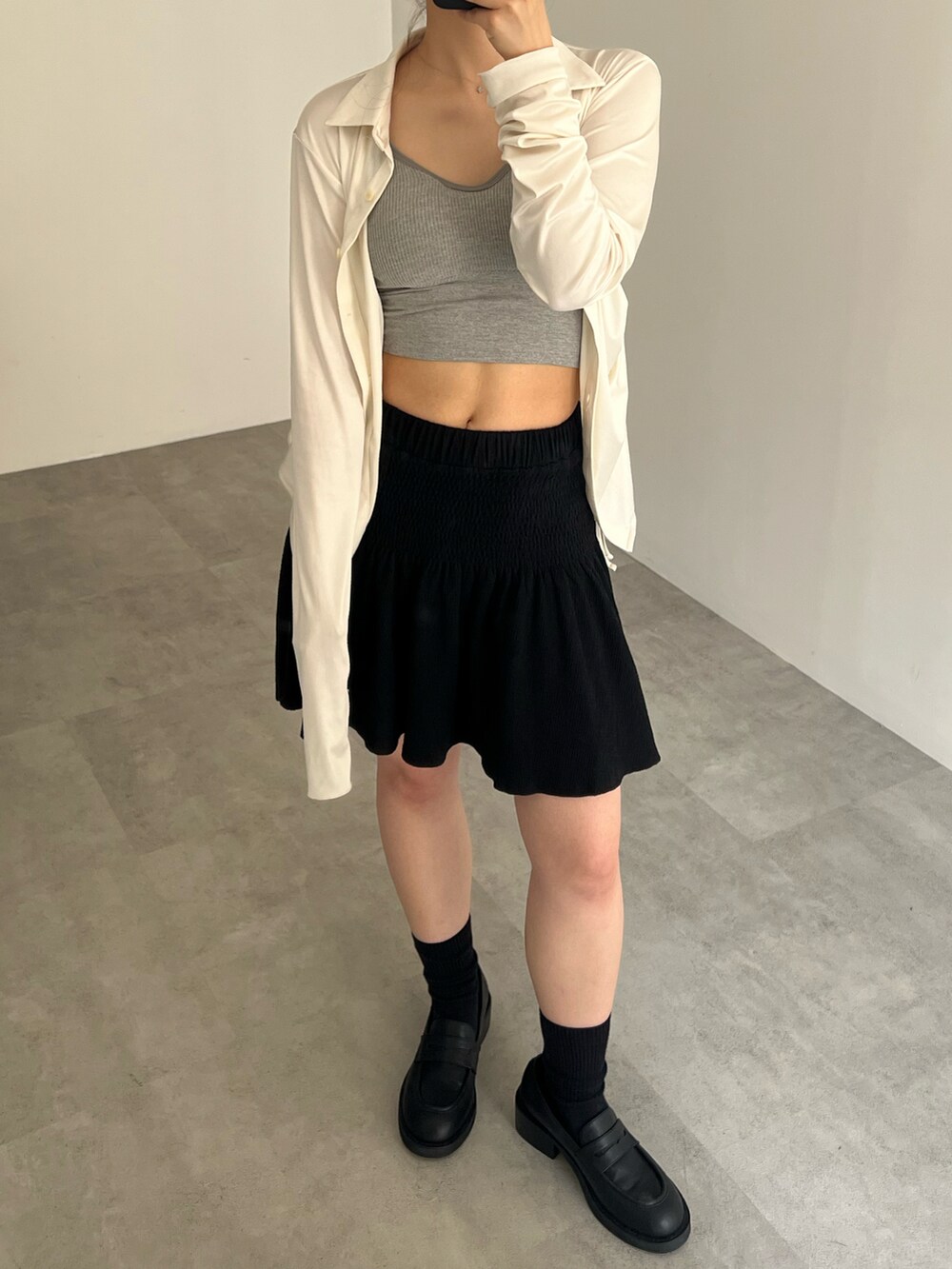 ホワイト系のシャツ/ブラウス、ブラック系のスカート、ブラック系のローファーを着用したレディースの夏コーディネートの2枚目の写真