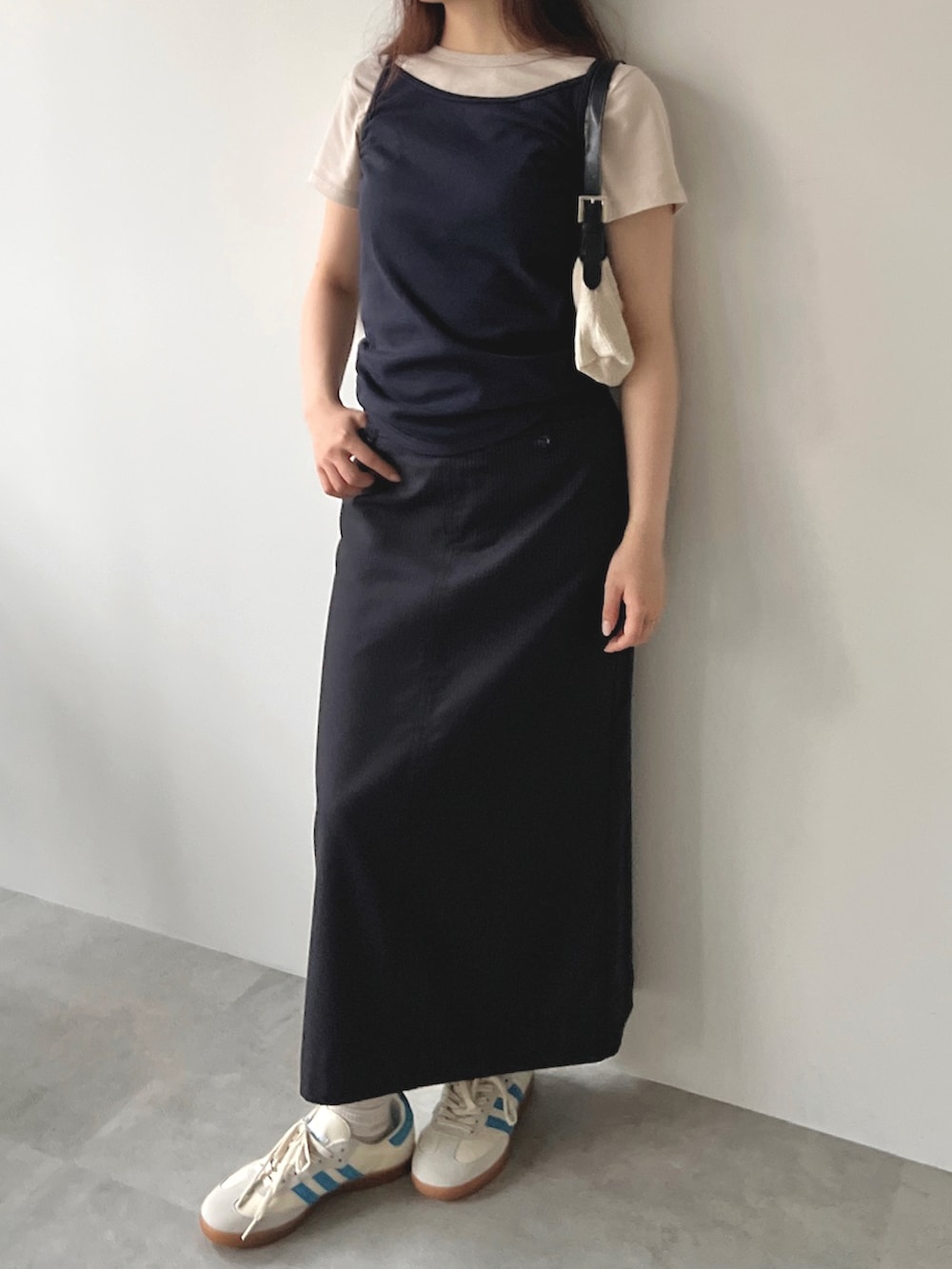 ブルー系のキャミソール、ベージュ系のTシャツ/カットソー、ブラック系のスカートを着用したレディースの夏コーディネートの2枚目の写真