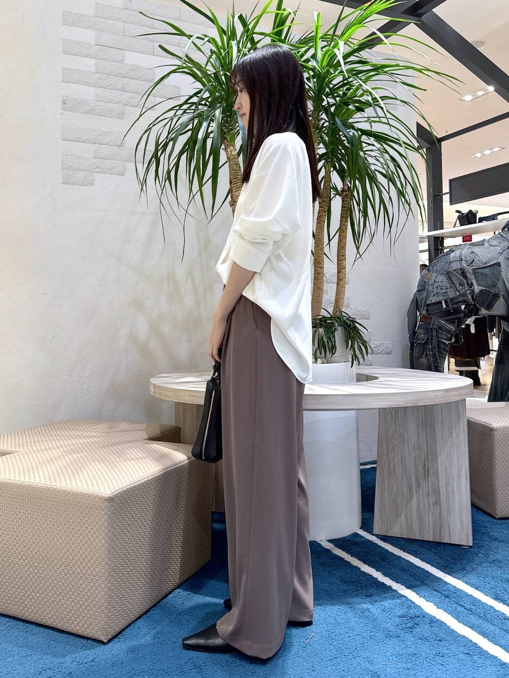 グリーン系のスラックス、ホワイト系のシャツ/ブラウス、ブラック系のショルダーバッグを着用したレディースの冬コーディネートの2枚目の写真