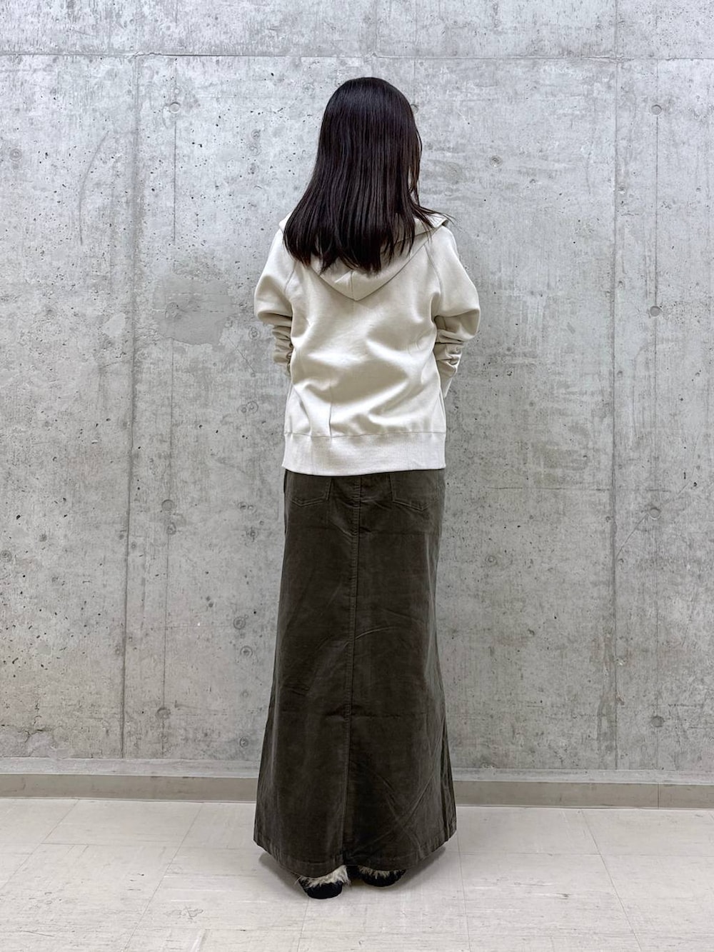 ブラック系のショルダーバッグ、ホワイト系のTシャツ/カットソー、ブラウン系のスカートを着用したレディースの秋コーディネートの2枚目の写真