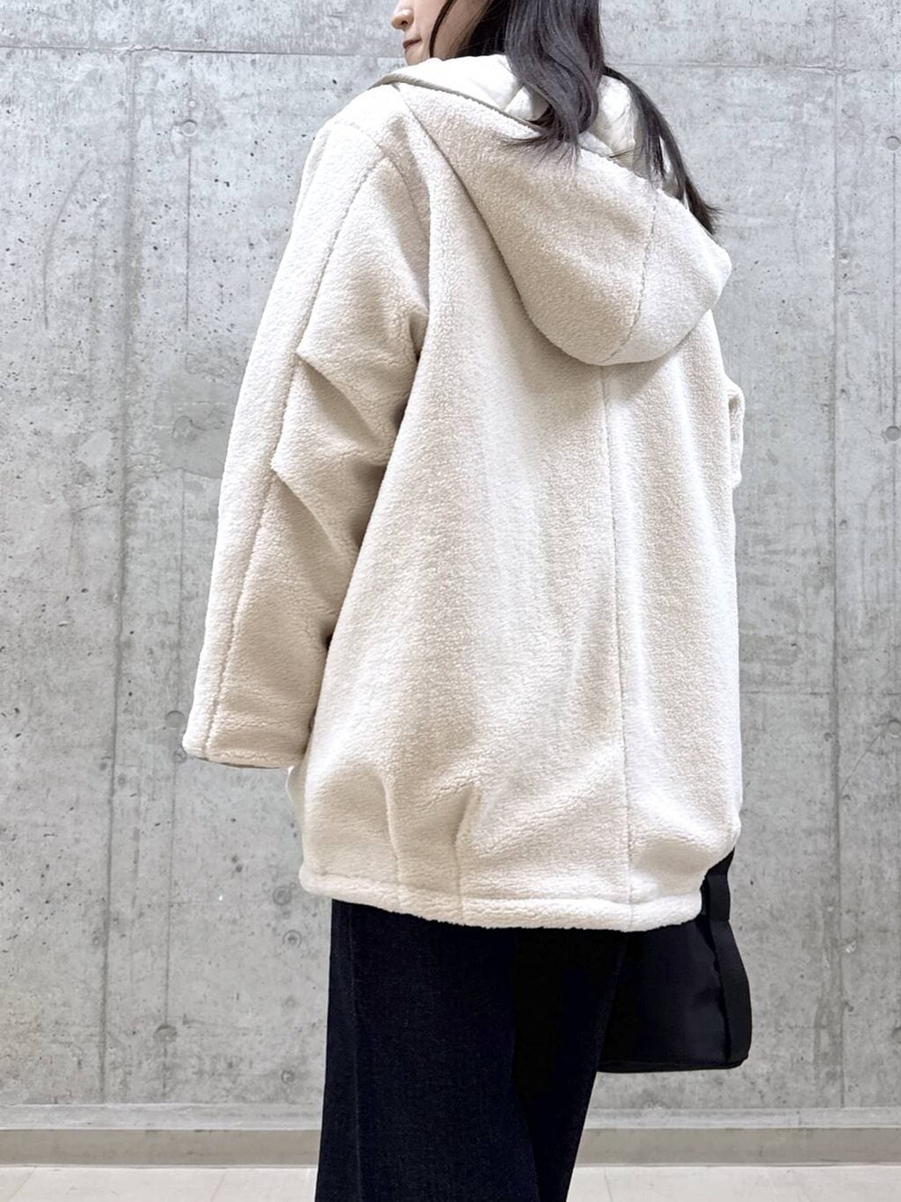 ブルー系のデニムパンツ、パープル系のニット/セーター、ホワイト系のその他アウターを着用したレディースの冬コーディネートの4枚目の写真