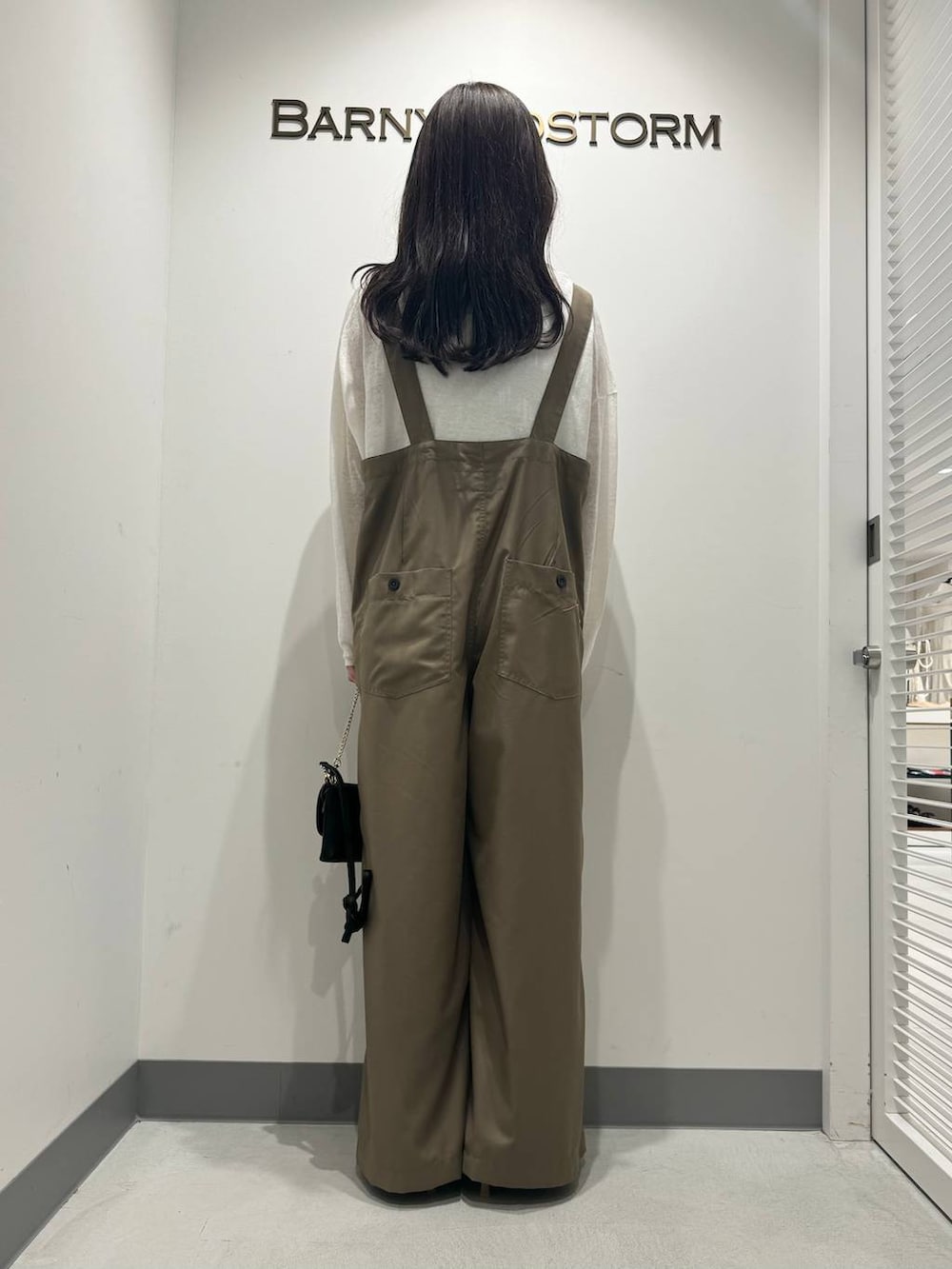 ベージュ系のスリッポン、ブラック系のショルダーバッグ、ホワイト系のニット/セーターを着用したレディースの春コーディネートの3枚目の写真