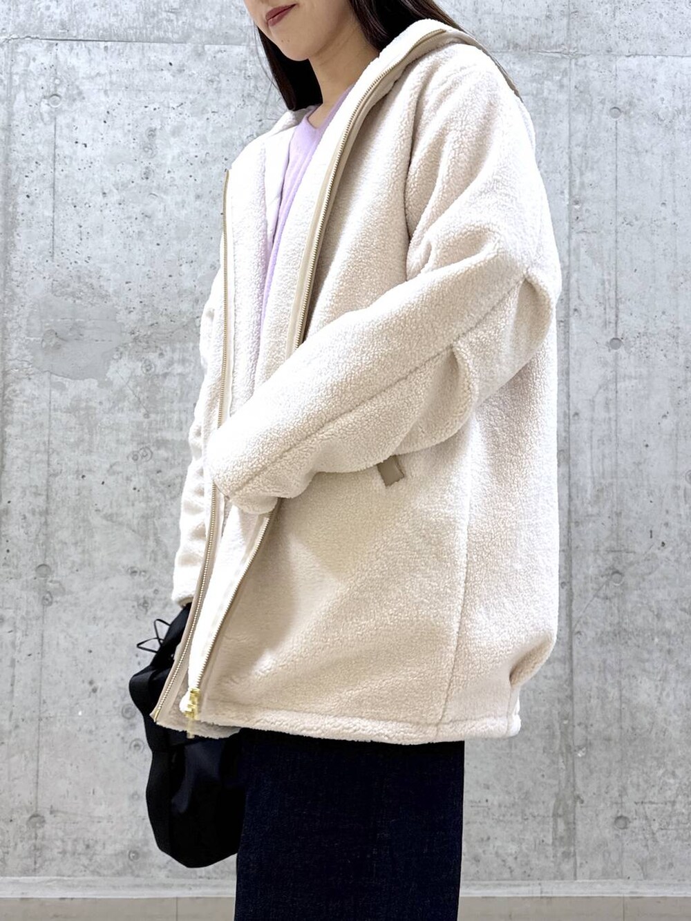 ブルー系のデニムパンツ、パープル系のニット/セーター、ホワイト系のその他アウターを着用したレディースの冬コーディネートの3枚目の写真