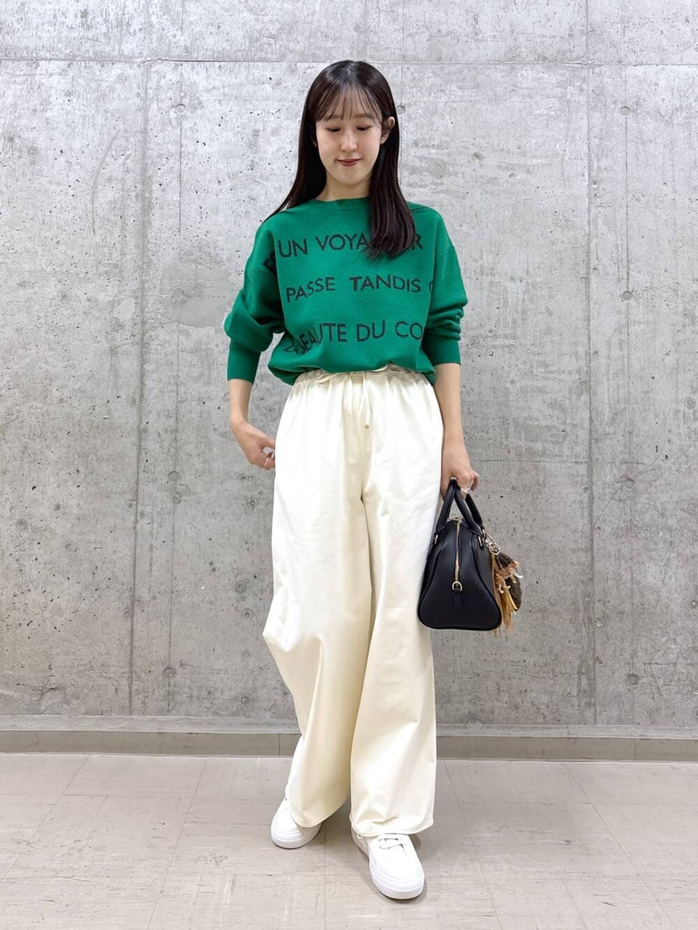 ブラック系のボストンバッグ、グリーン系のニット/セーター、ホワイト系のその他パンツを着用したレディースの秋コーディネートの5枚目の写真