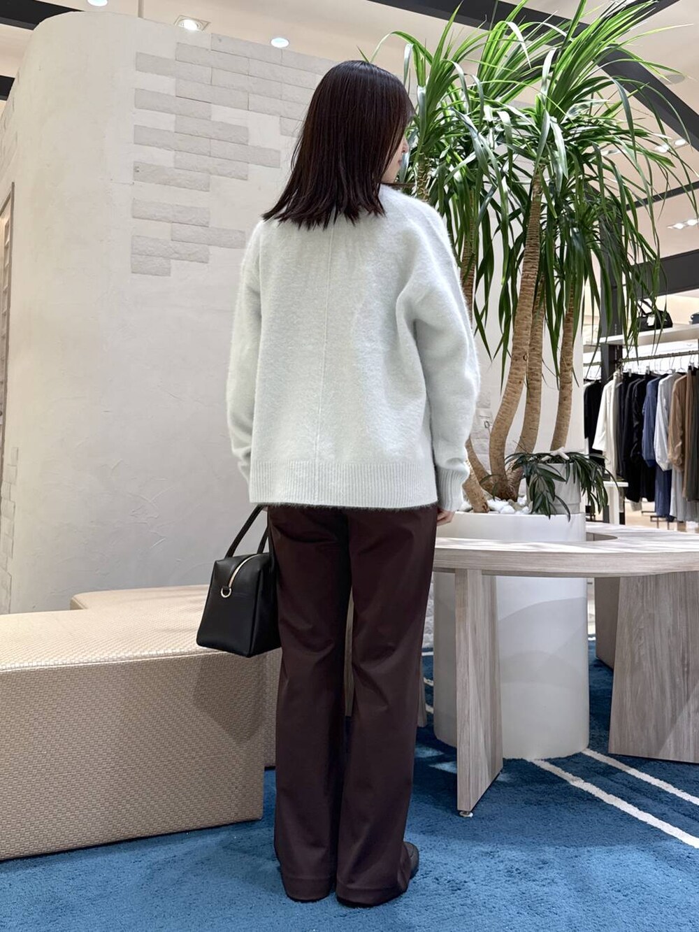 ブラック系のボストンバッグ、ブルー系のニット/セーター、ブラウン系のその他パンツを着用したレディースの秋コーディネートの3枚目の写真