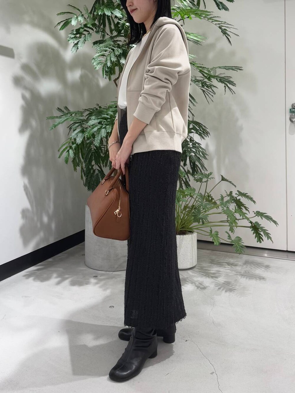 ホワイト系のTシャツ/カットソー、ベージュ系のパーカー、イエロー系のボストンバッグを着用したレディースの冬コーディネートの2枚目の写真