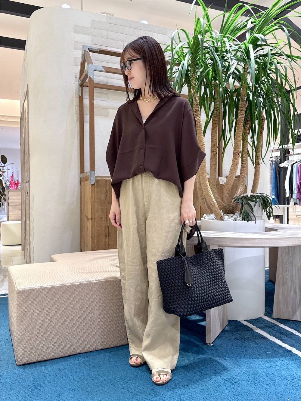 ブラック系のトートバッグ、ベージュ系のその他パンツ、ブラウン系のシャツ/ブラウスを着用したレディースの夏コーディネートの5枚目の写真