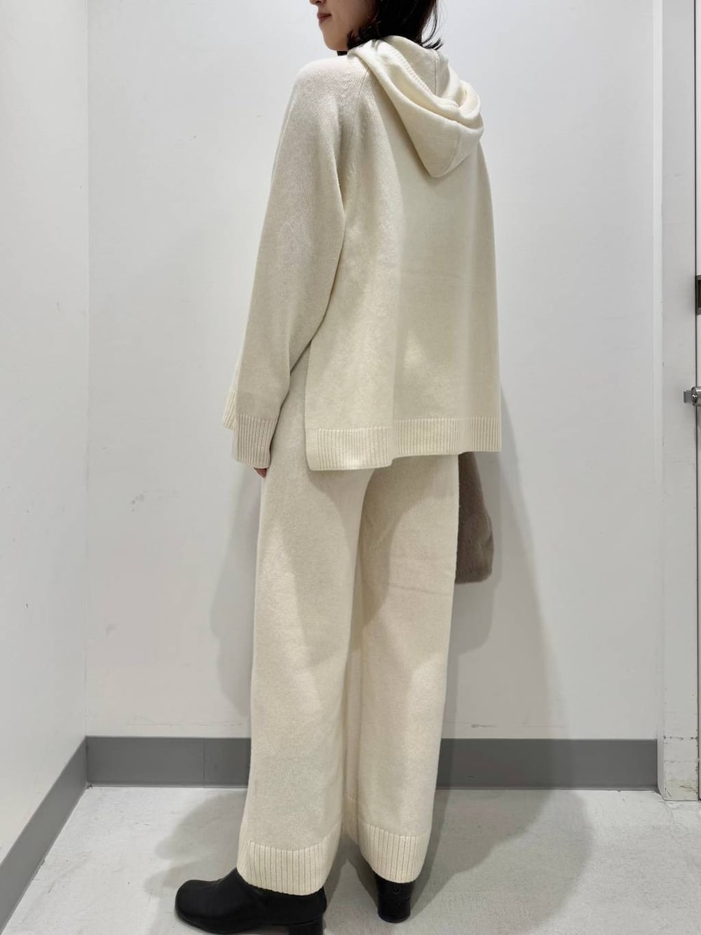 ホワイト系のニット/セーター、ブラウン系のトートバッグ、ホワイト系のその他パンツを着用したレディースの冬コーディネートの3枚目の写真