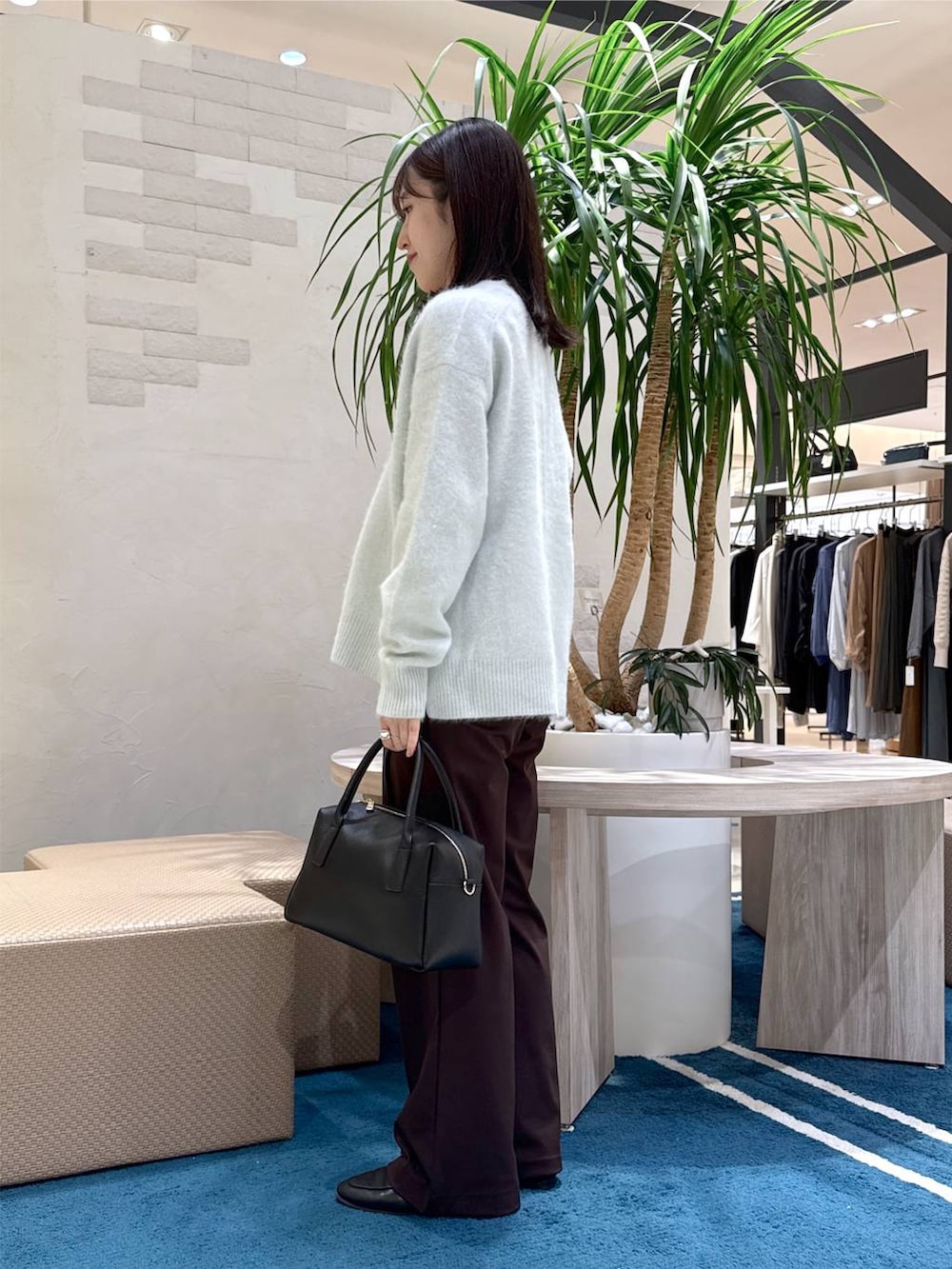 ブラック系のボストンバッグ、ブルー系のニット/セーター、ブラウン系のその他パンツを着用したレディースの秋コーディネートの2枚目の写真