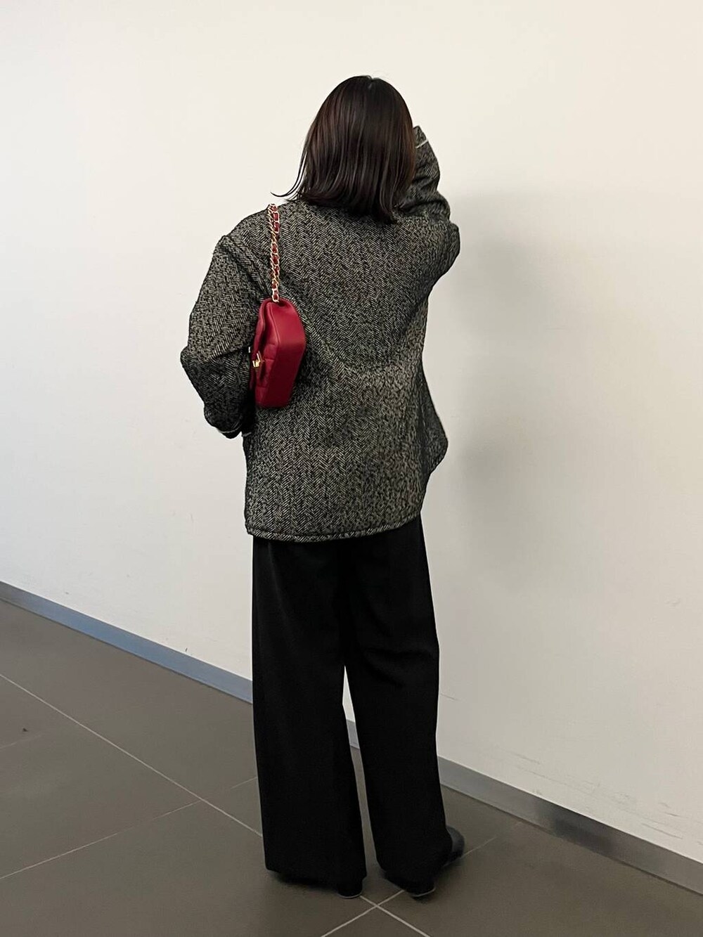 グレー系のニット/セーター、ブラック系のブーツ、ブラック系のノーカラーコートを着用したレディースの冬コーディネートの3枚目の写真