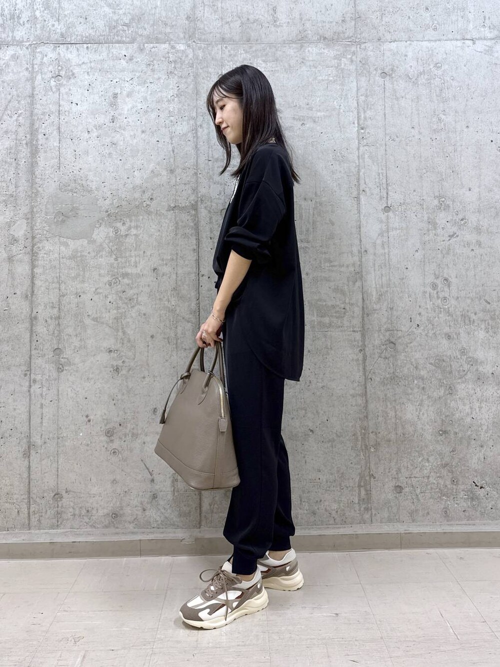 ブラック系のシャツ/ブラウス、ブラック系のその他パンツ、ブラウン系のスニーカーを着用したレディースの秋コーディネートの2枚目の写真