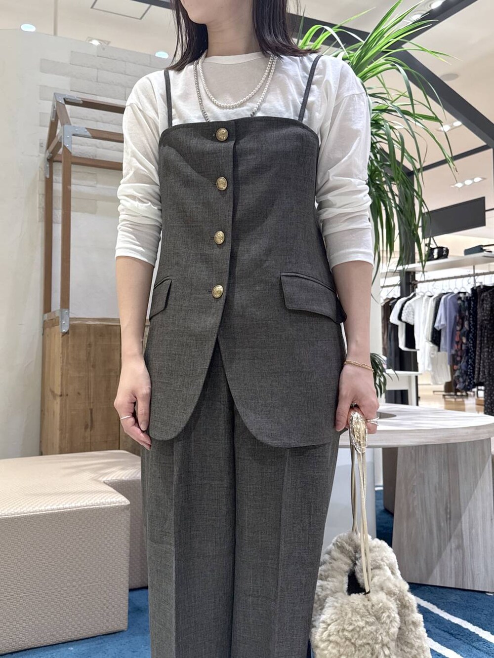 ブラック系のサンダル、ブラウン系のベスト、ホワイト系のTシャツ/カットソーを着用したレディースの夏コーディネートの4枚目の写真