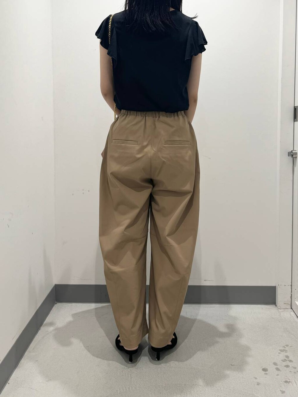 ブラウン系のショルダーバッグ、ブラック系のTシャツ/カットソー、ベージュ系のその他パンツを着用したレディースの夏コーディネートの3枚目の写真