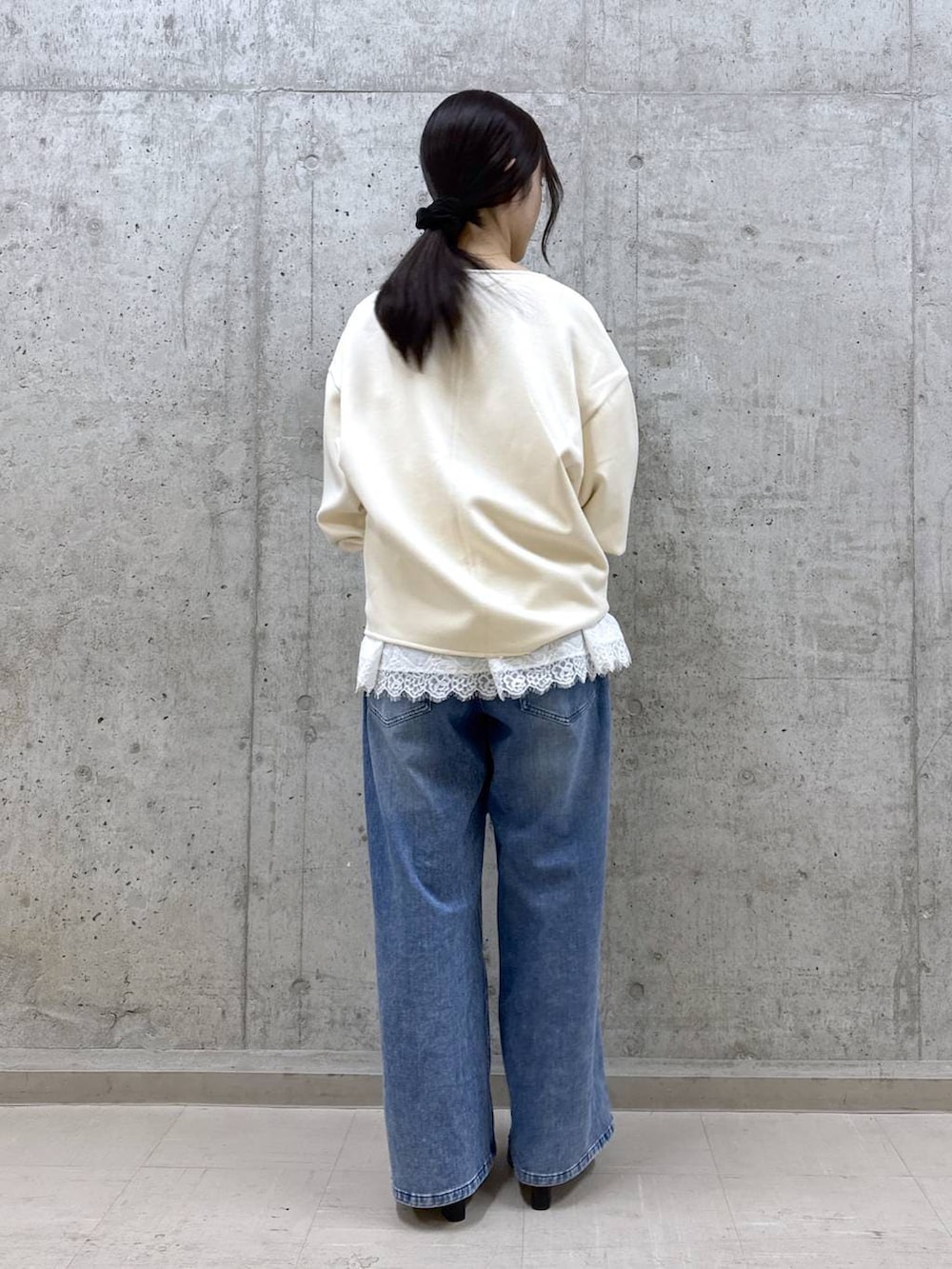 ブルー系のデニムパンツ、ブラック系のブーツ、ホワイト系のスウェットを着用したレディースの冬コーディネートの4枚目の写真