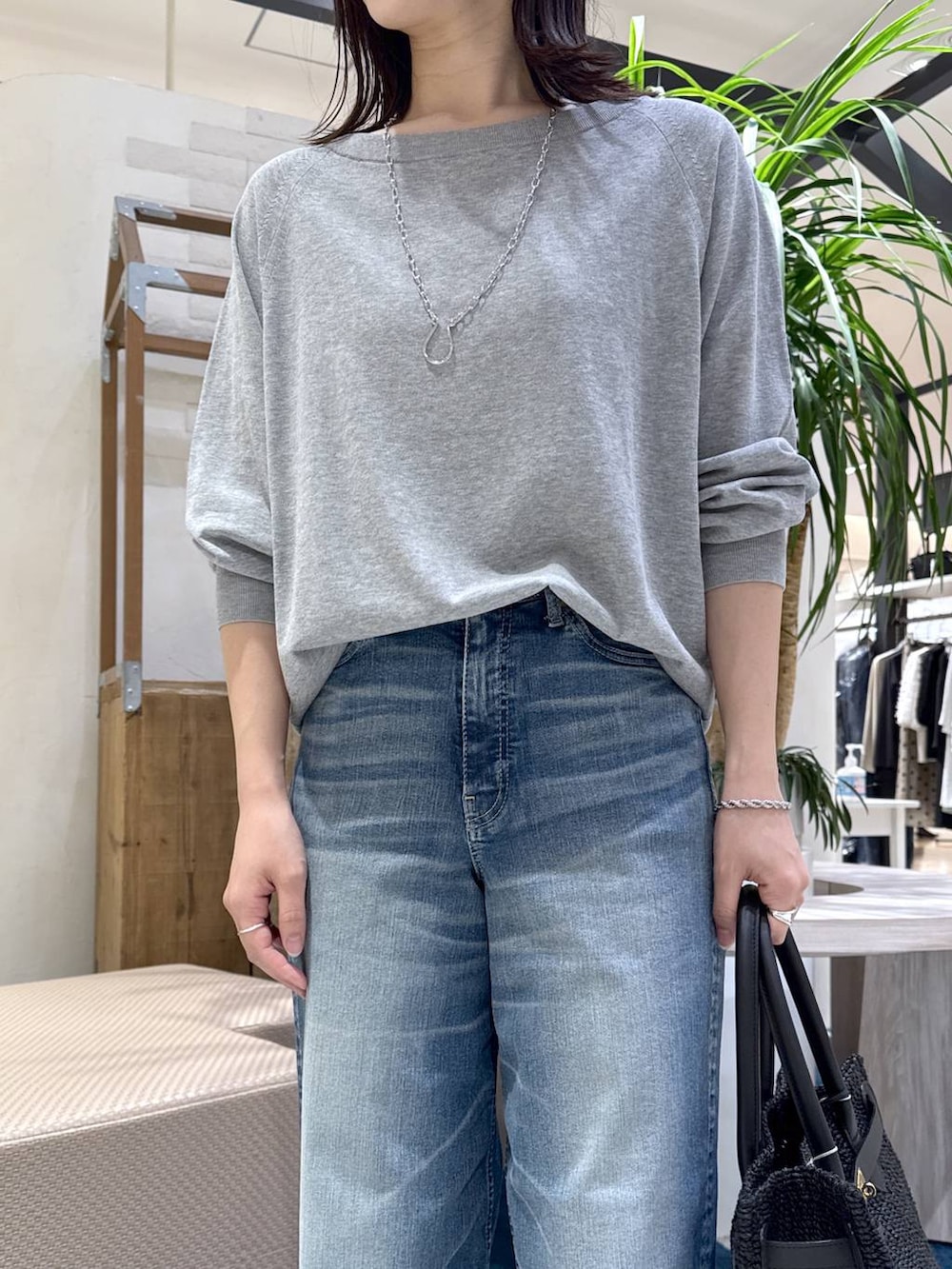 グレー系のニット/セーター、ブルー系のデニムパンツ、ブラウン系のスリッポンを着用したレディースの春コーディネートの4枚目の写真